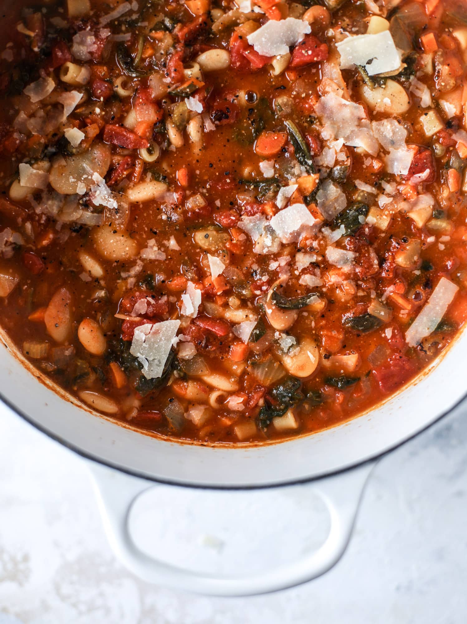 This fire roasted minestrone soup is like a huge in a bowl. Chock full of vegetables, fire roasted tomatoes and butter beans, the bowl is topped off with a delicious kale pesto that adds even more flavor. Satisfying, healthy and perfect for dinner! I howsweeteats.com #minestrone #soup