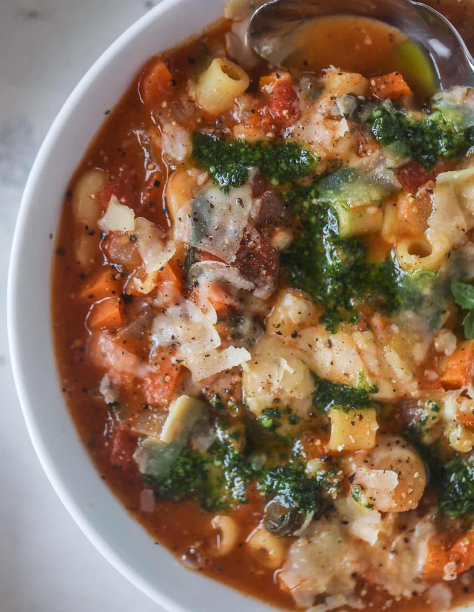 This fire roasted minestrone soup is like a huge in a bowl. Chock full of vegetables, fire roasted tomatoes and butter beans, the bowl is topped off with a delicious kale pesto that adds even more flavor. Satisfying, healthy and perfect for dinner! I howsweeteats.com #minestrone #soup