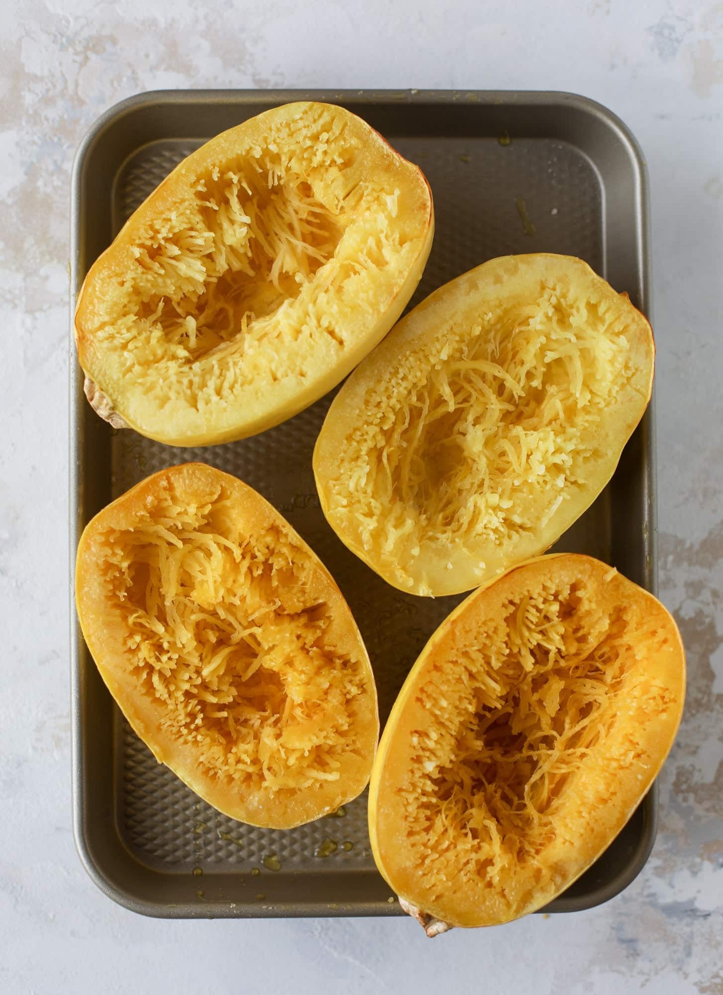 Spaghetti squash parmesan is a delicious weeknight meal! Topped with marinara or bolognese, melty cheese and fresh herbs, it's easy and delicious! I howsweeteats.com #spaghettisquash #parmesan