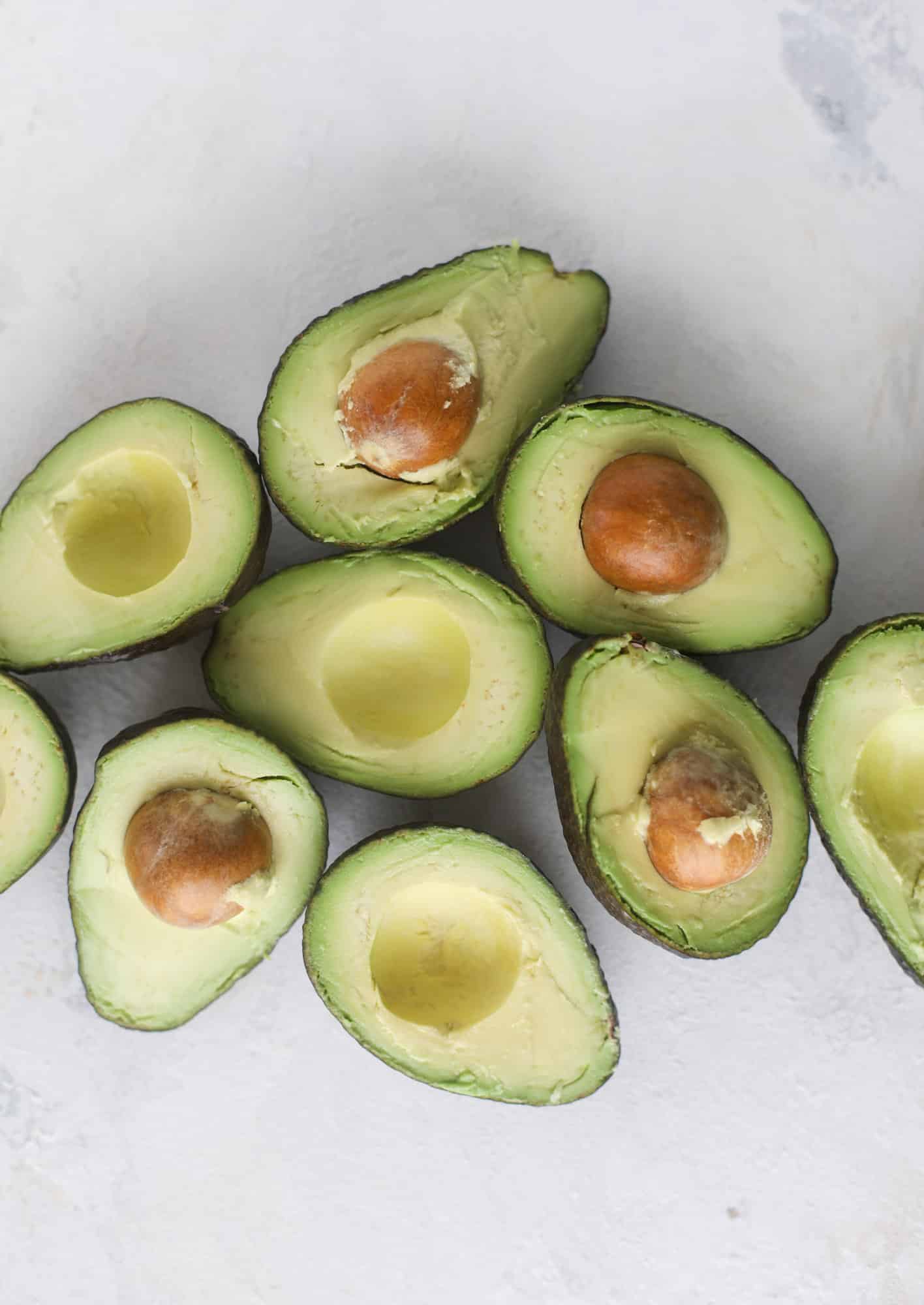 These baked avocados are stuffed with a cheesy chicken mixture and drizzled with sriracha yogurt sauce! Super delicious and an easy weeknight meal. I howsweeteats.com #baked #avocados