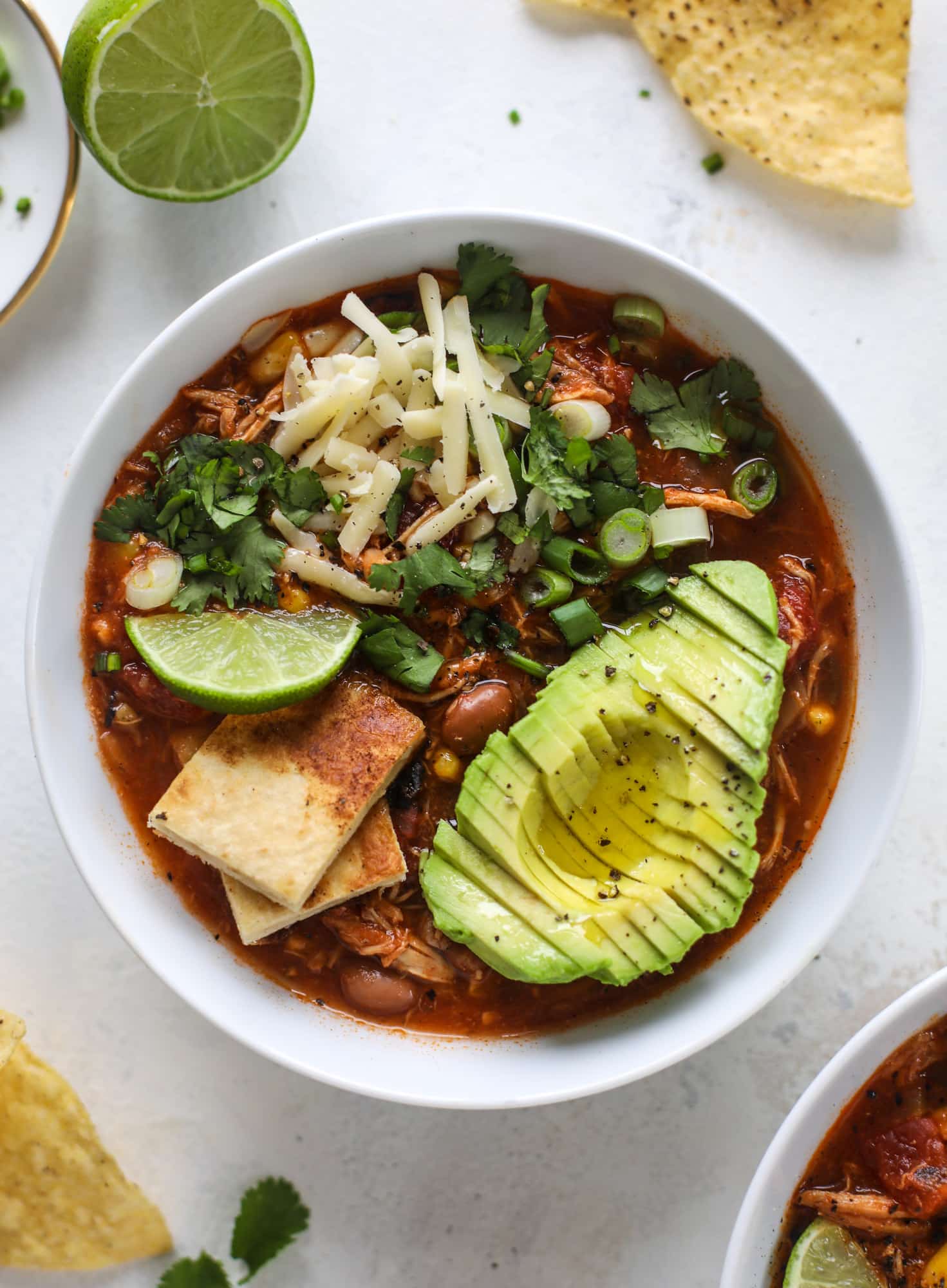 This flavorful chicken taco soup can be made on the stovetop or in the slow cooker. It's hearty and topped with cheese quesadilla croutons! I howsweeteats.com #chicken #tacosoup