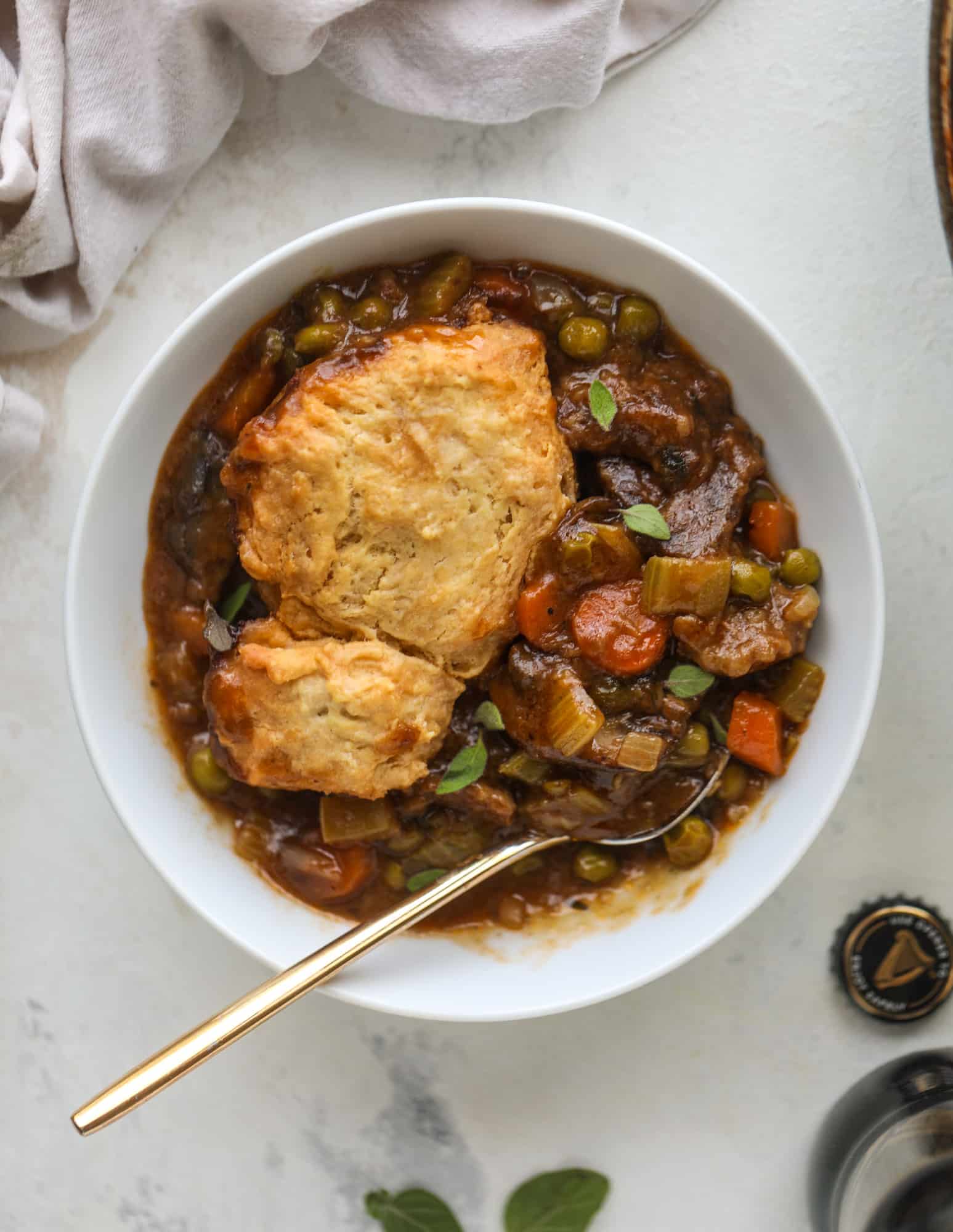 A perfect cold weather comfort food meal, Guiness pot pie has tender, fall-apart beef, lots of vegetables and is topped with buttery beer bread biscuits! I howsweeteats.com #guinness #potpie