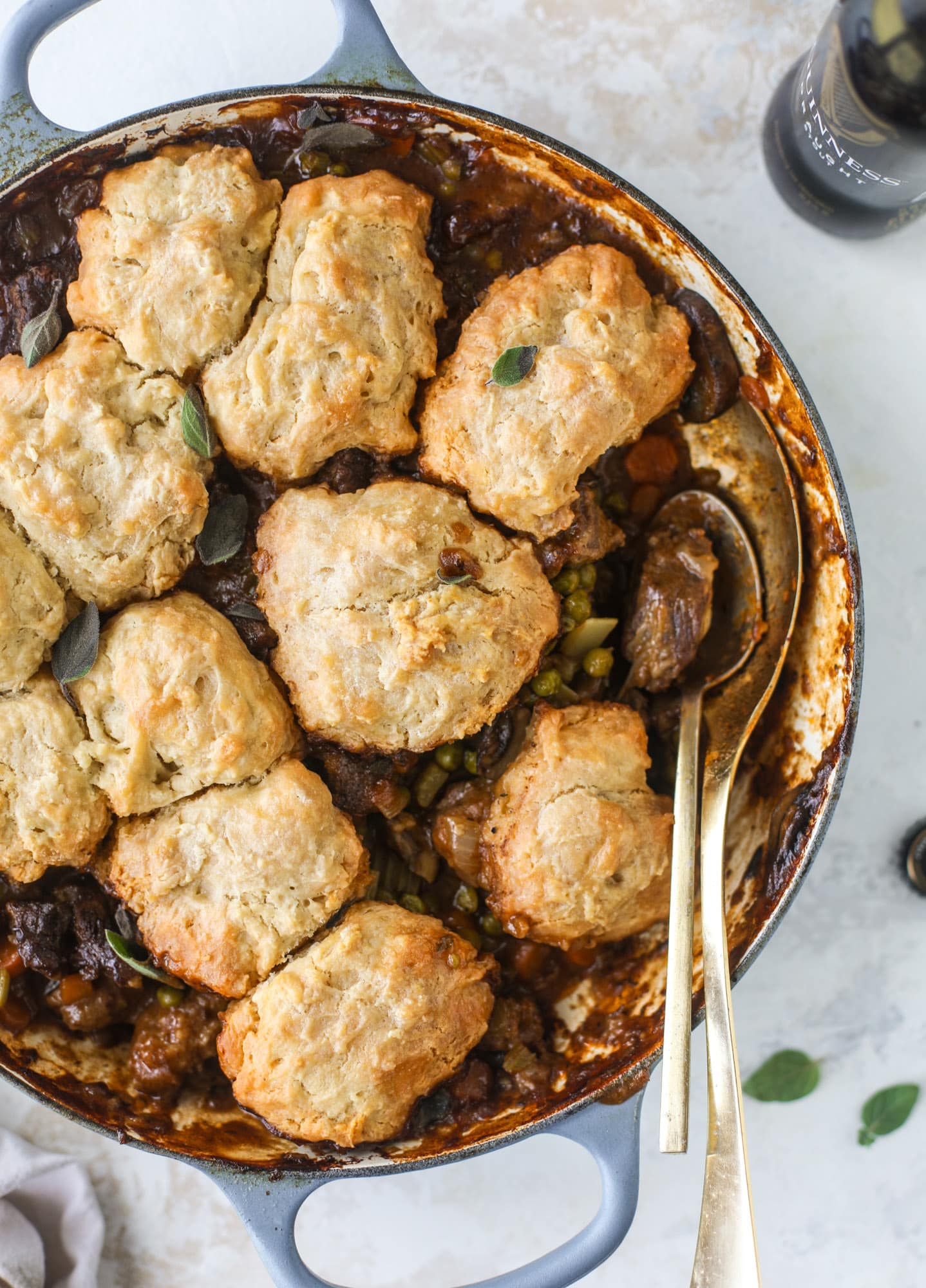 A perfect cold weather comfort food meal, Guiness pot pie has tender, fall-apart beef, lots of vegetables and is topped with buttery beer bread biscuits! I howsweeteats.com #guinness #potpie