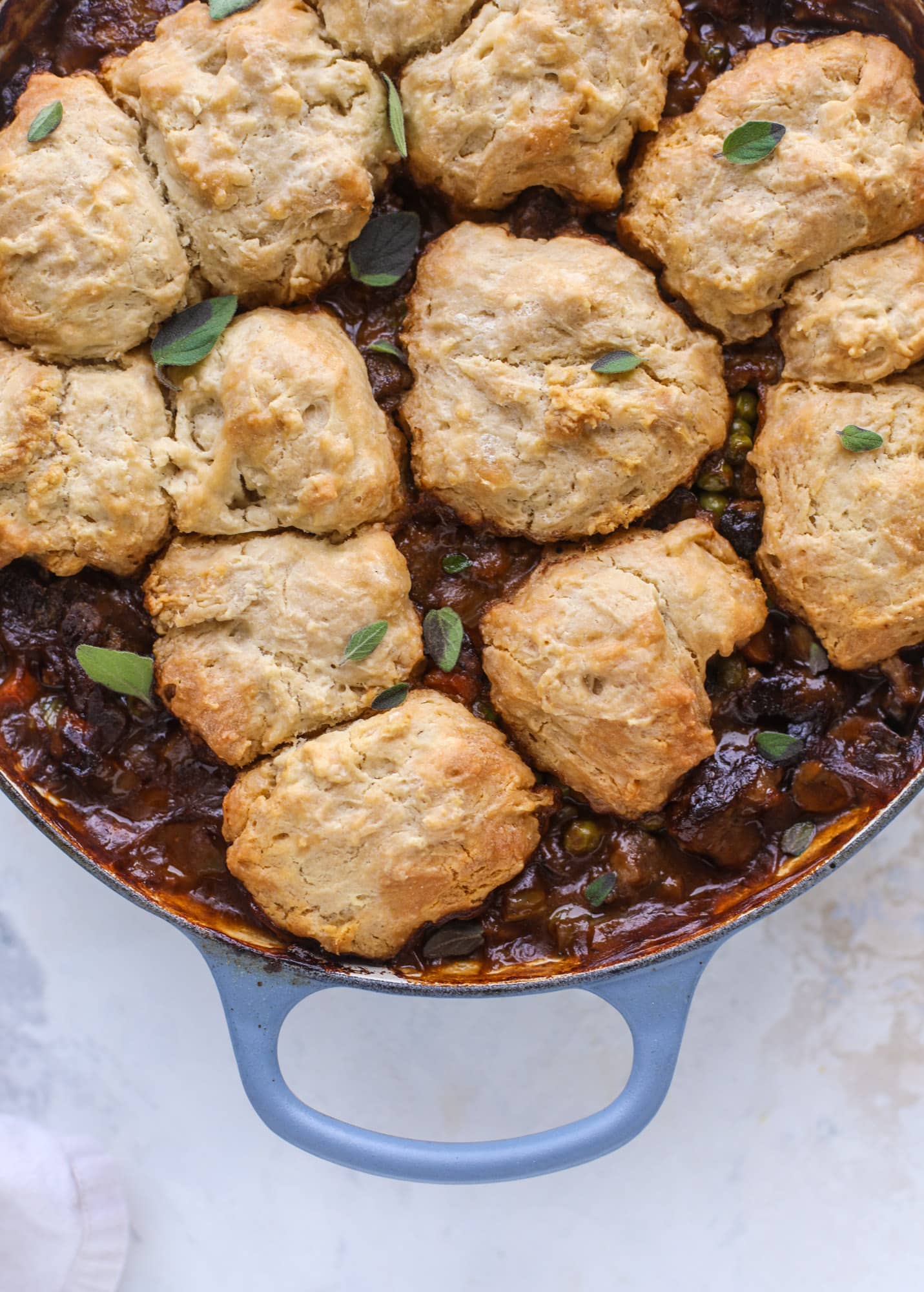 A perfect cold weather comfort food meal, Guiness pot pie has tender, fall-apart beef, lots of vegetables and is topped with buttery beer bread biscuits! I howsweeteats.com #guinness #potpie