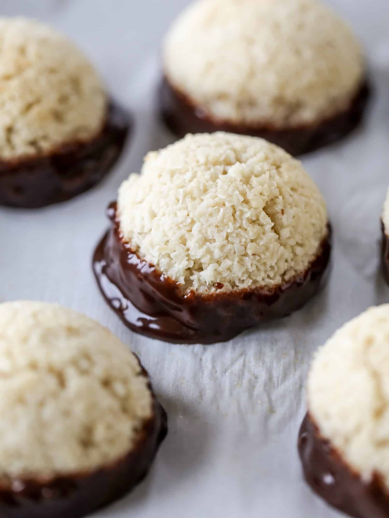 Classic chewy, slightly gooey coconut macaroons dipped in an irish cream chocolate ganache. Easy to make and gluten free too! I howsweeteats.com #irishcream #coconutmacaroons