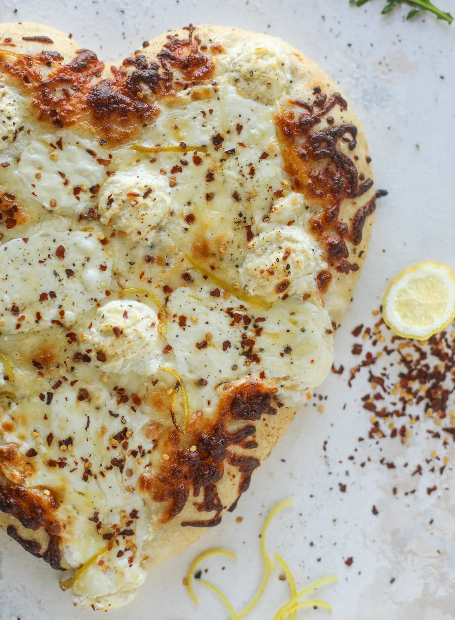 Our favorite white pizza recipe has four different kinds of cheese and comes on a garlic bread crust! Topped with crushed pepper and lemon - tons of flavor! I howsweeteats.com #white #pizza