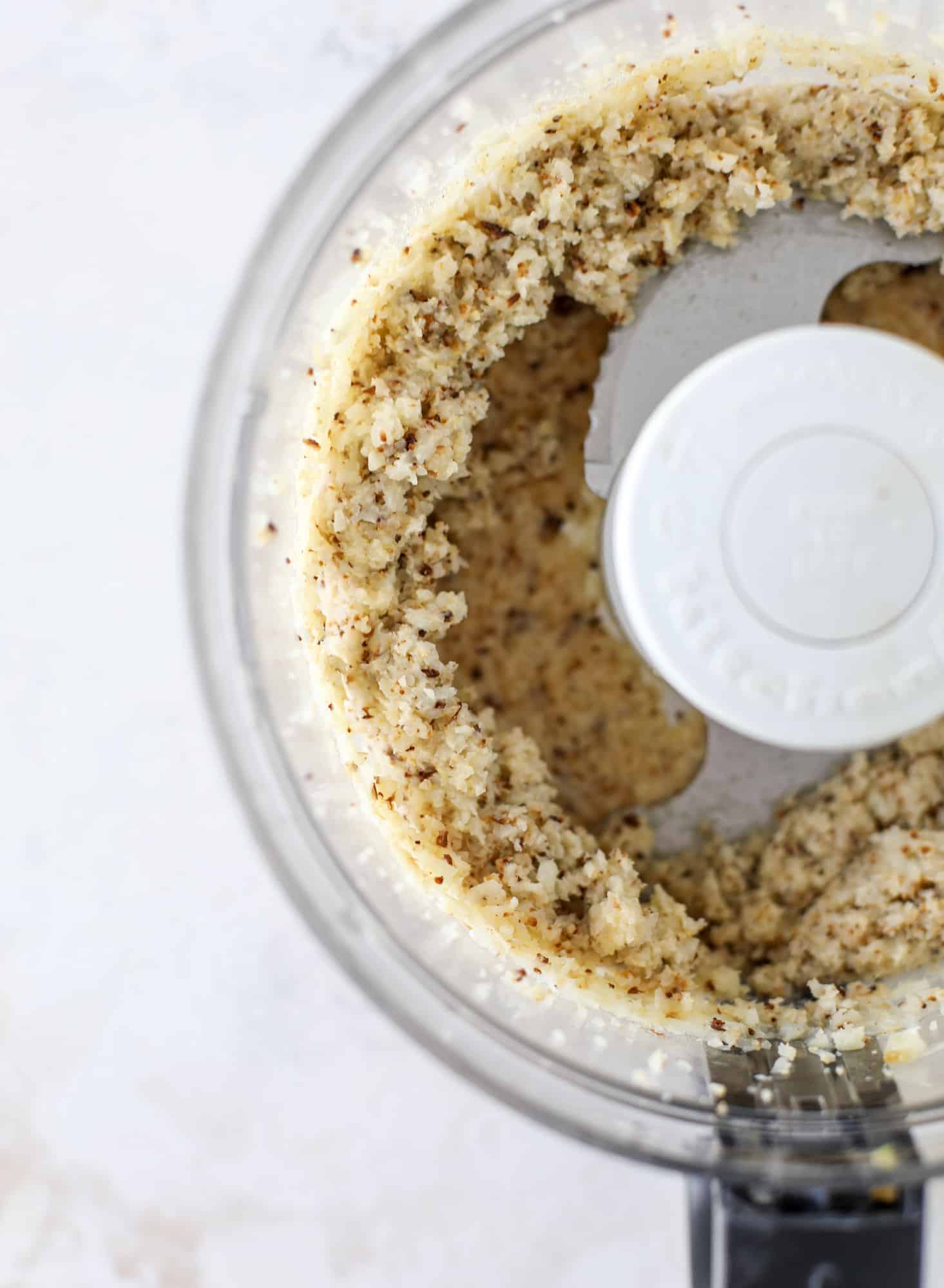 This falafel is hearty and flavorful, served over the creamiest cauliflower hummus, with tomatoes, olive, cucumbers and feta. Yum! I howsweeteats.com #falafel #cauliflowerhummus