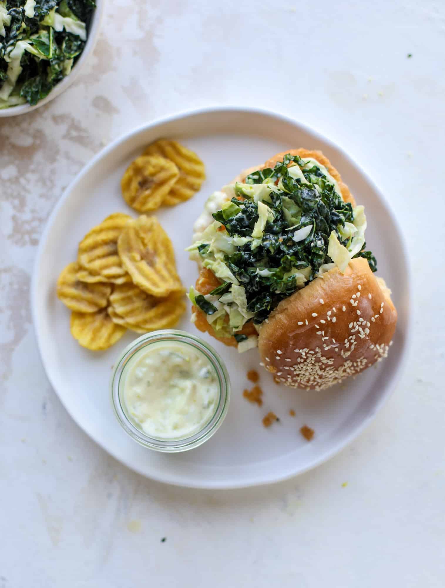 A light and crispy fish sandwich made with a simple beer batter and topped with a hearty, creamy kale cole slaw. Loaded with flavor! I howsweeteats.com #crispyfish #sandwich