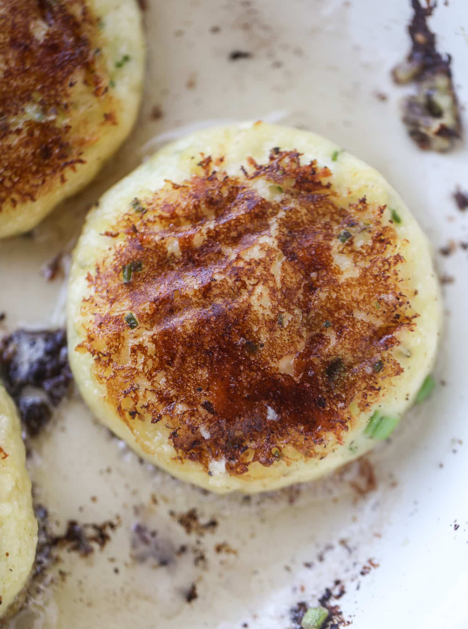 Loaded mashed potato pancakes are the perfect comfort food or side dish to a hearty meat. Crispy mashed potatoes with aged cheddar. Delicious! I howsweeteats.com #mashedpotato #pancakes
