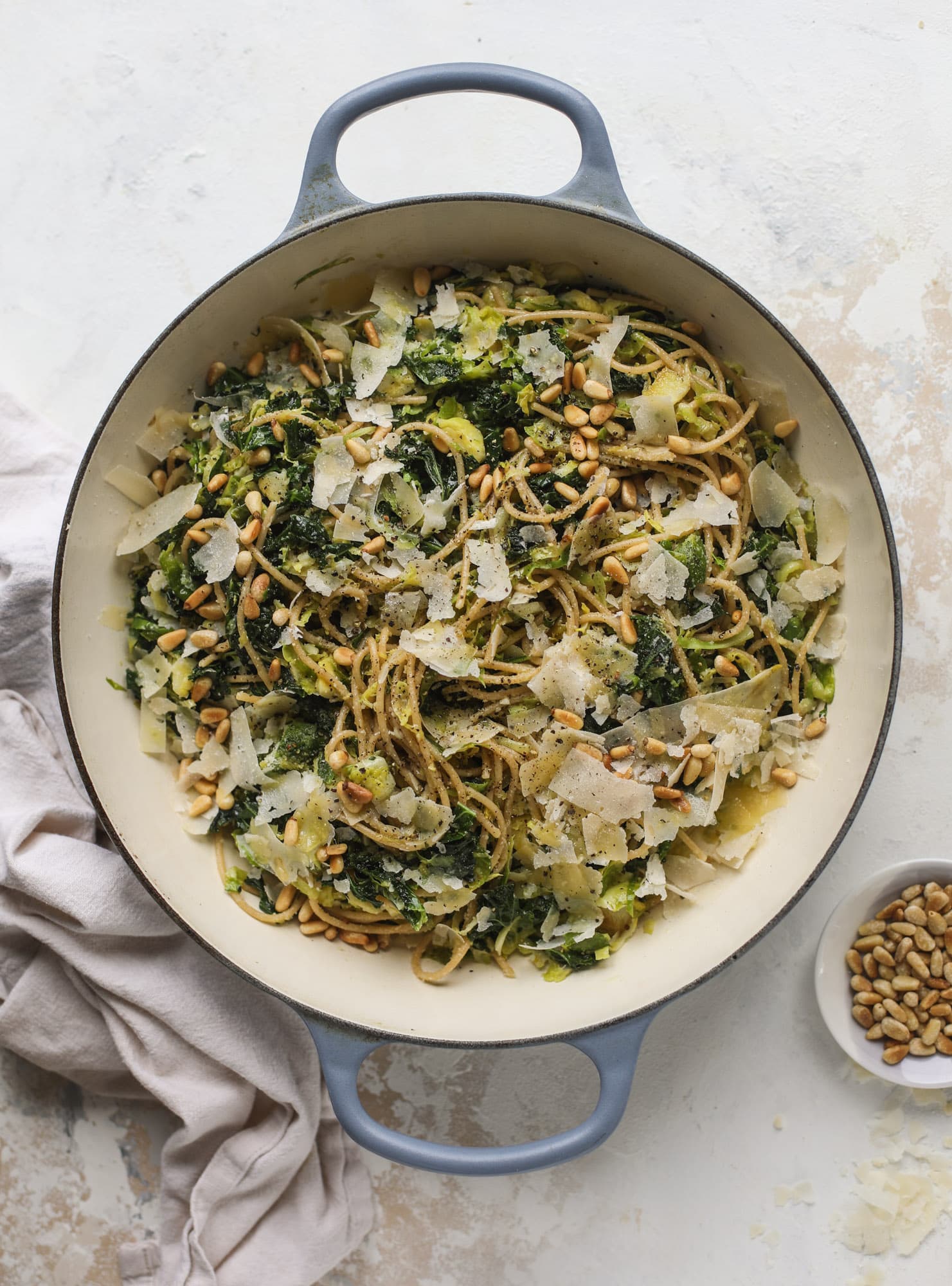 This brussels spaghetti with kale, parmesan and pine nuts is a super flavorful, quick and easy weeknight meal. You can add in a protein if you wish! I howsweeteats.com #brussels #spaghetti