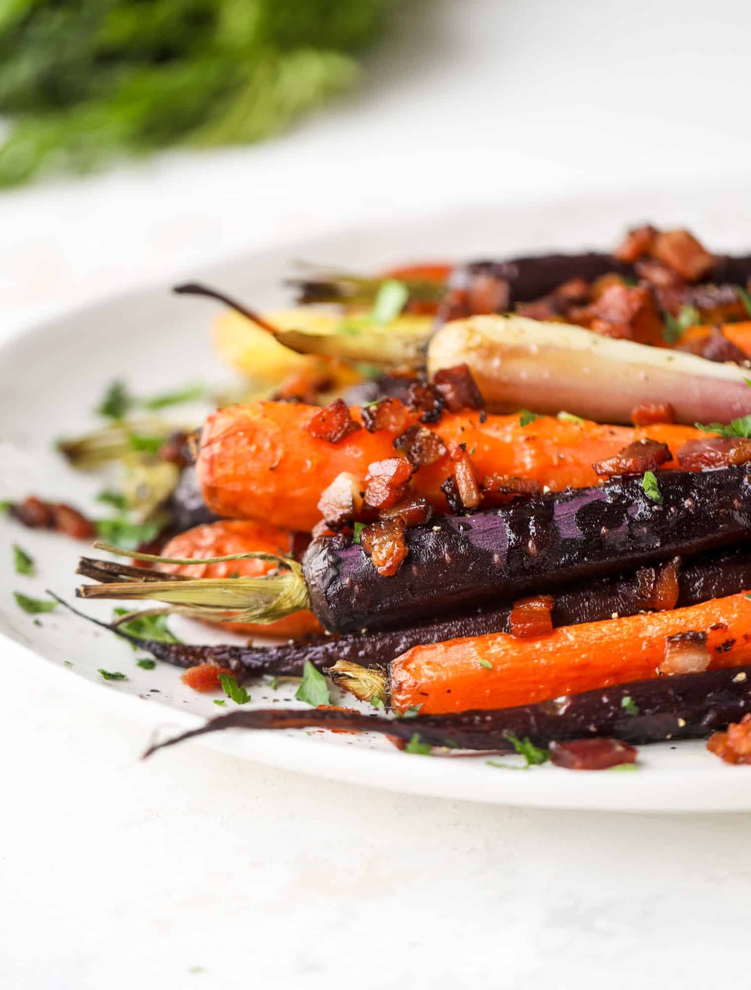 Sweet carrots are drizzled with bacon fat and chopped bacon, then roasted until they are tender, sweet and caramely. So much flavor!