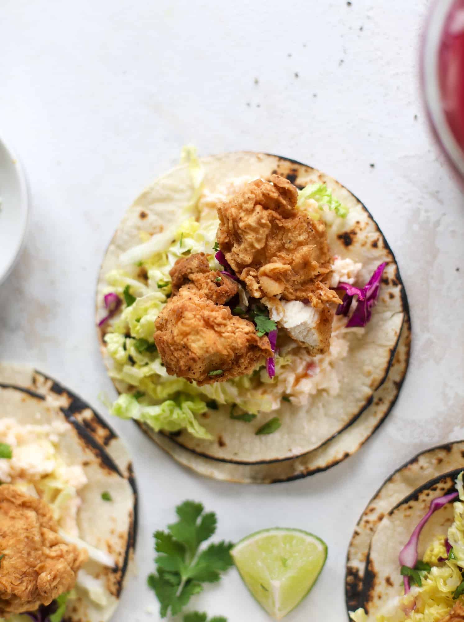 Taking crispy chicken tacos to the next level by wrapping them in a warm tortilla with gouda pimento cheese, lime cabbage and pickled onions!