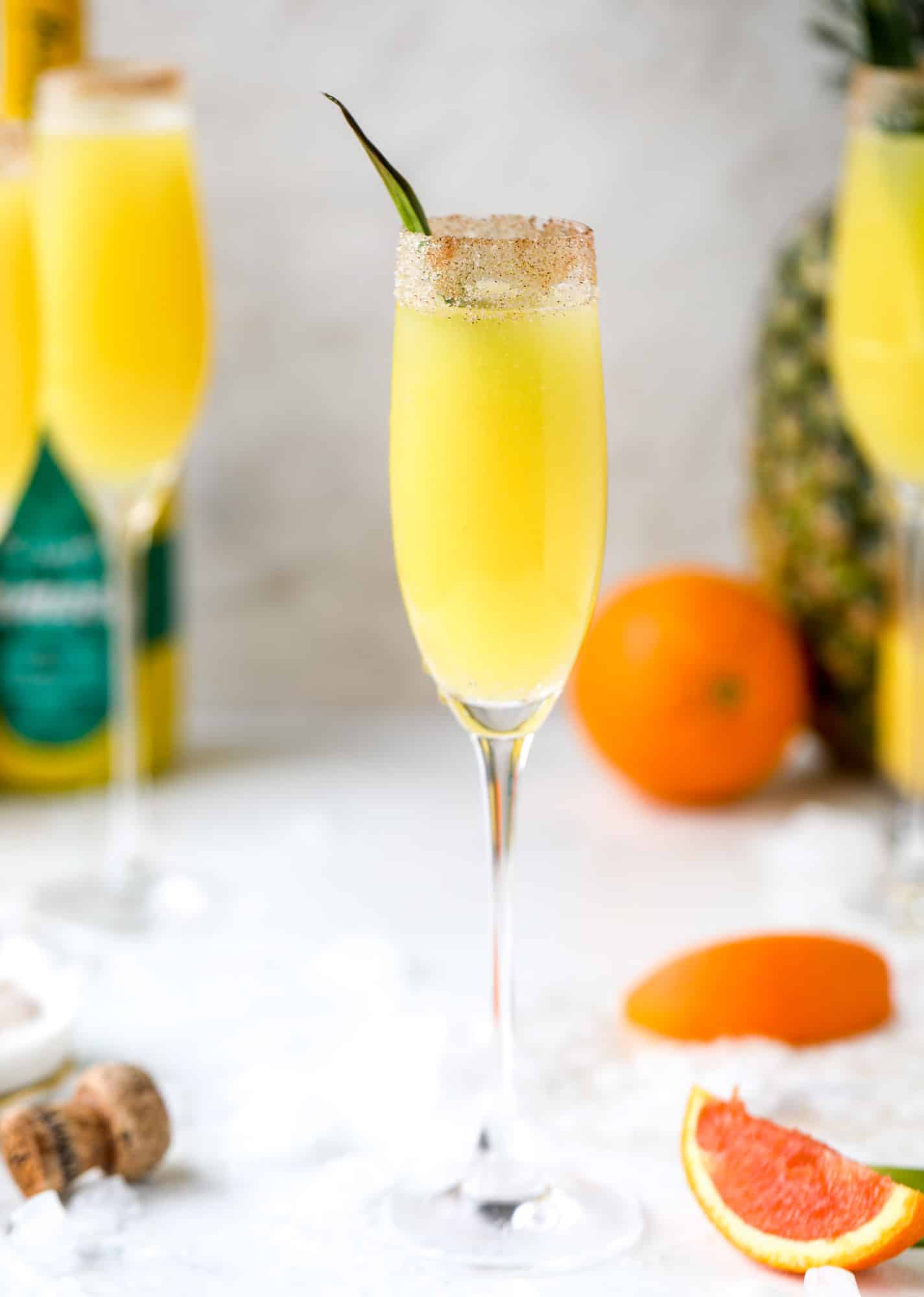 The hummingbird mimosa is a spin on the classic hummingbird cake: pineapple juice, orange juice, champagne and a cinnamon sugar rim! I howsweeteats.com #hummingbird #mimosa