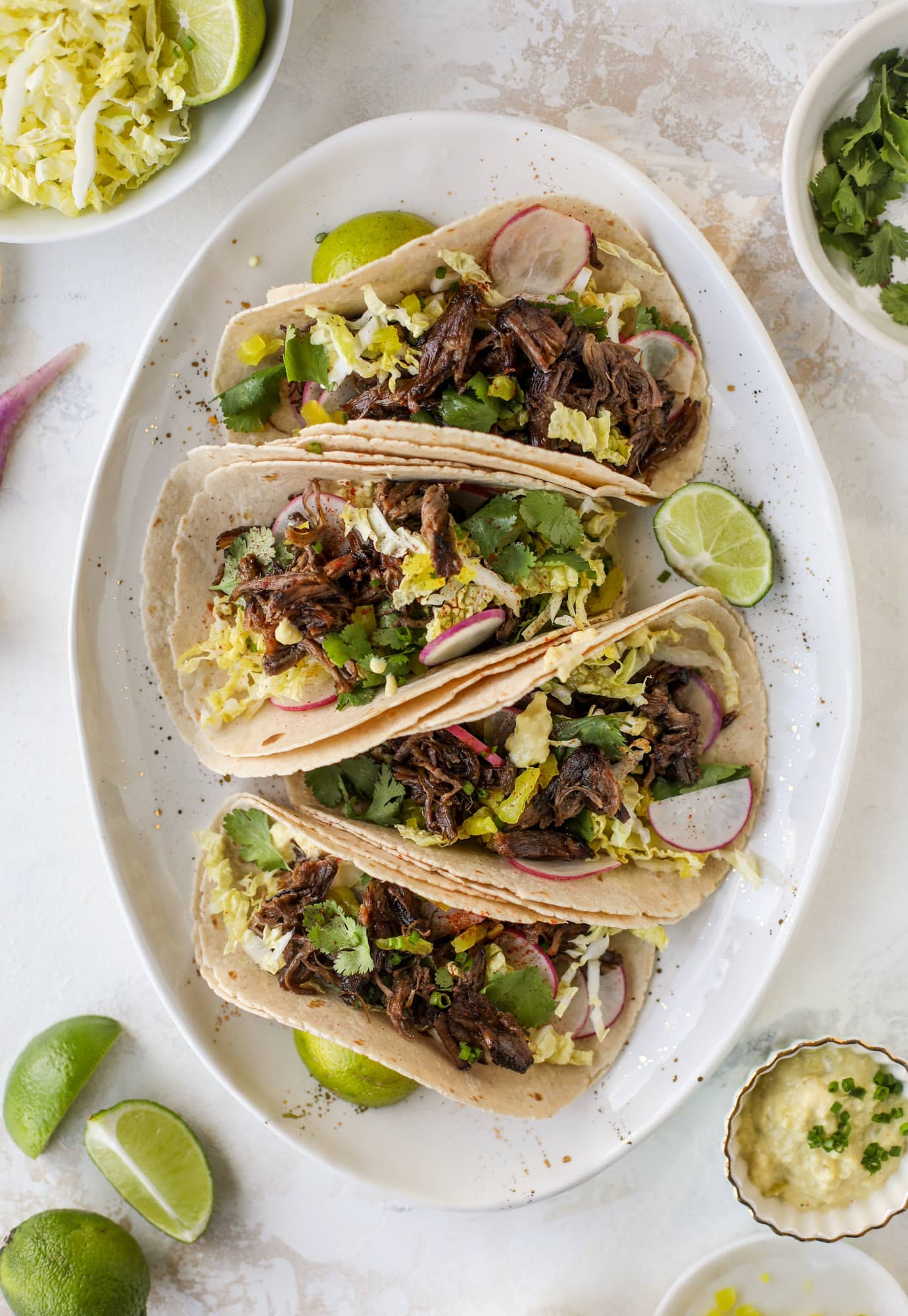These are the best smoky short rib tacos made in the slow cooker! Served with a banana pepper mustard and napa cabbage slaw, it's a flavor explosion.