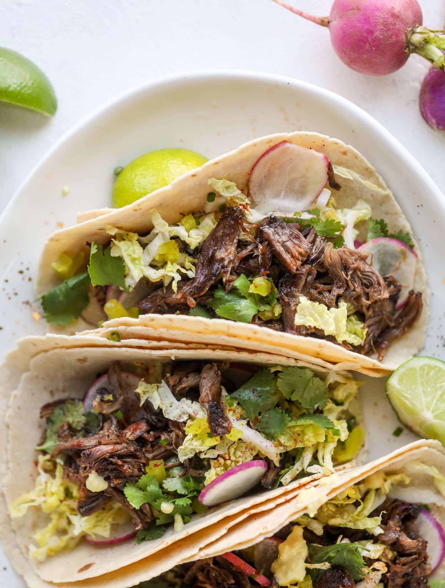 These are the best smoky short rib tacos made in the slow cooker! Served with a banana pepper mustard and napa cabbage slaw, it's a flavor explosion.