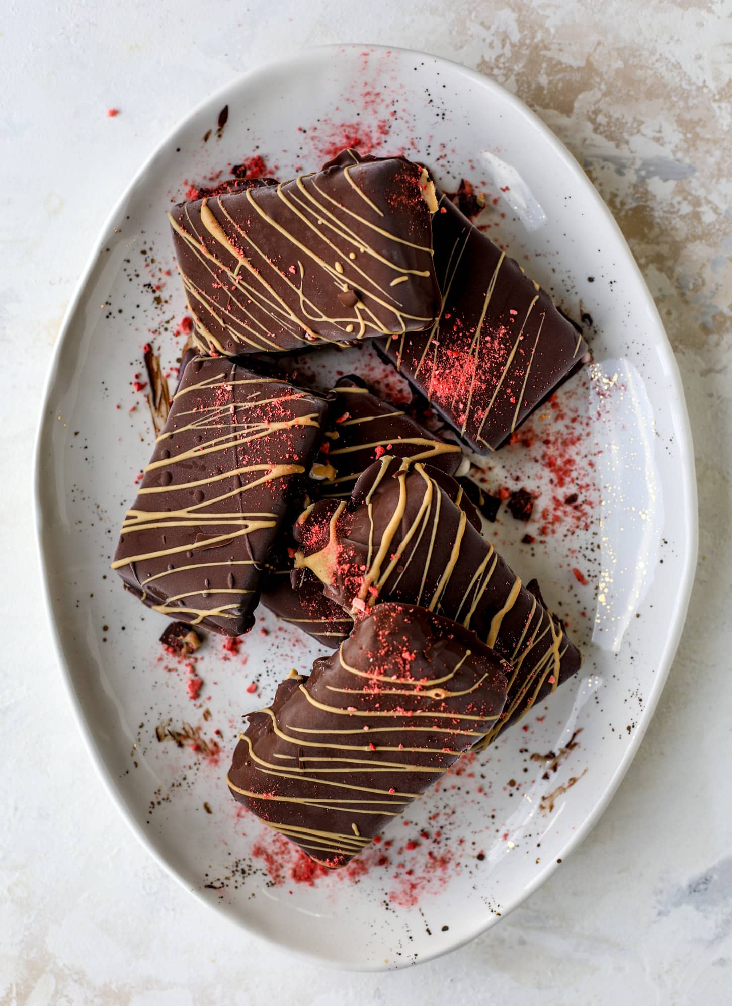 These frozen peanut butter jelly bars are super easy and made with an oatmilk frozen dessert, then covered in a dark chocolate shell. Delish!