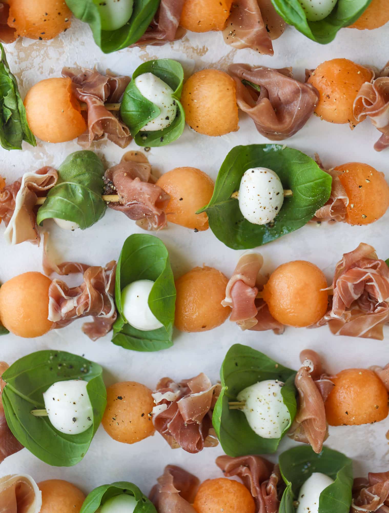 These cantaloupe prosciutto skewers are the perfect cantoloupe caprese snack! Salty prosciutto, sweet melon and fresh mozzarella drizzled with mint pesto!