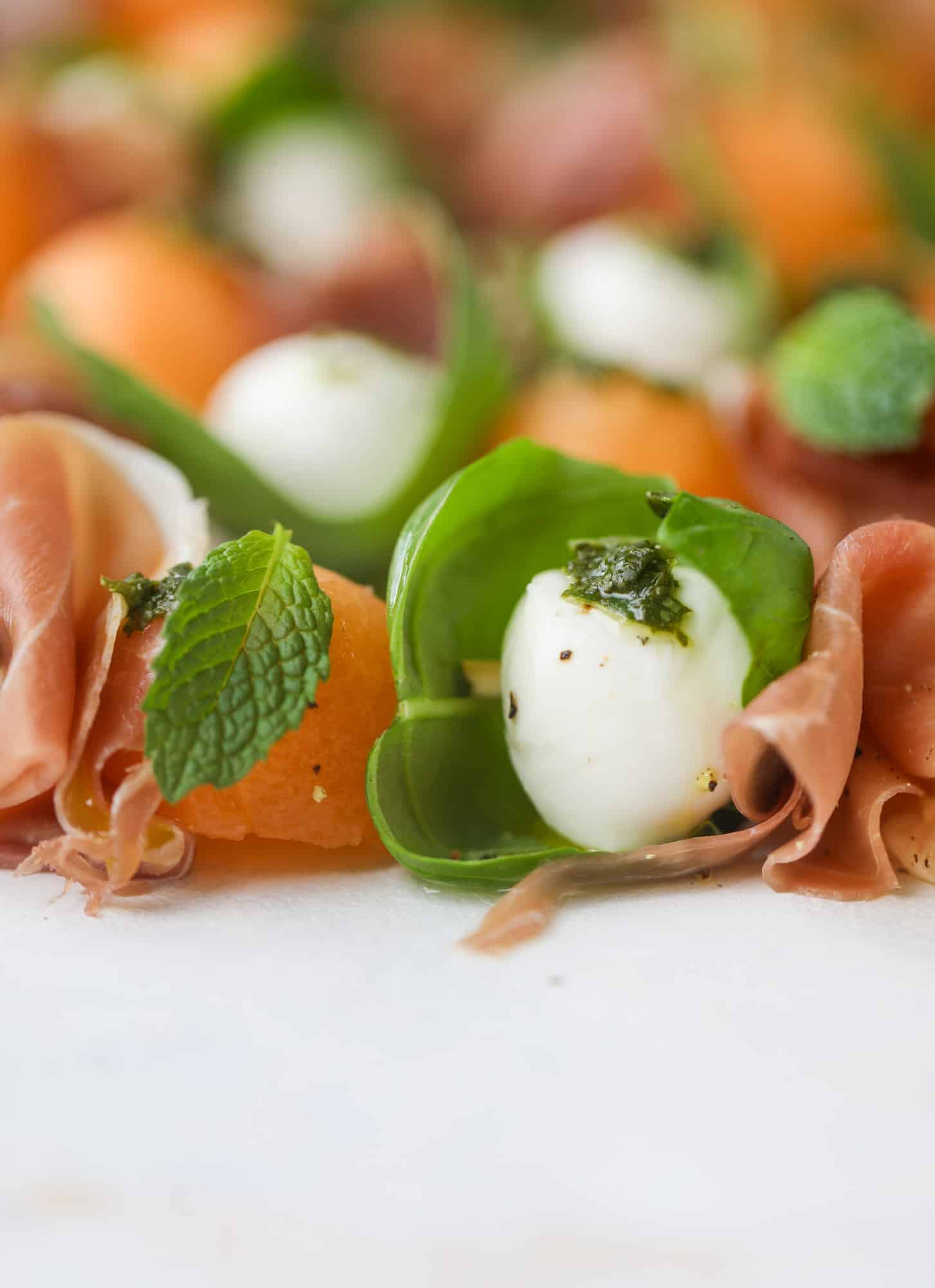 These cantaloupe prosciutto skewers are the perfect cantoloupe caprese snack! Salty prosciutto, sweet melon and fresh mozzarella drizzled with mint pesto!
