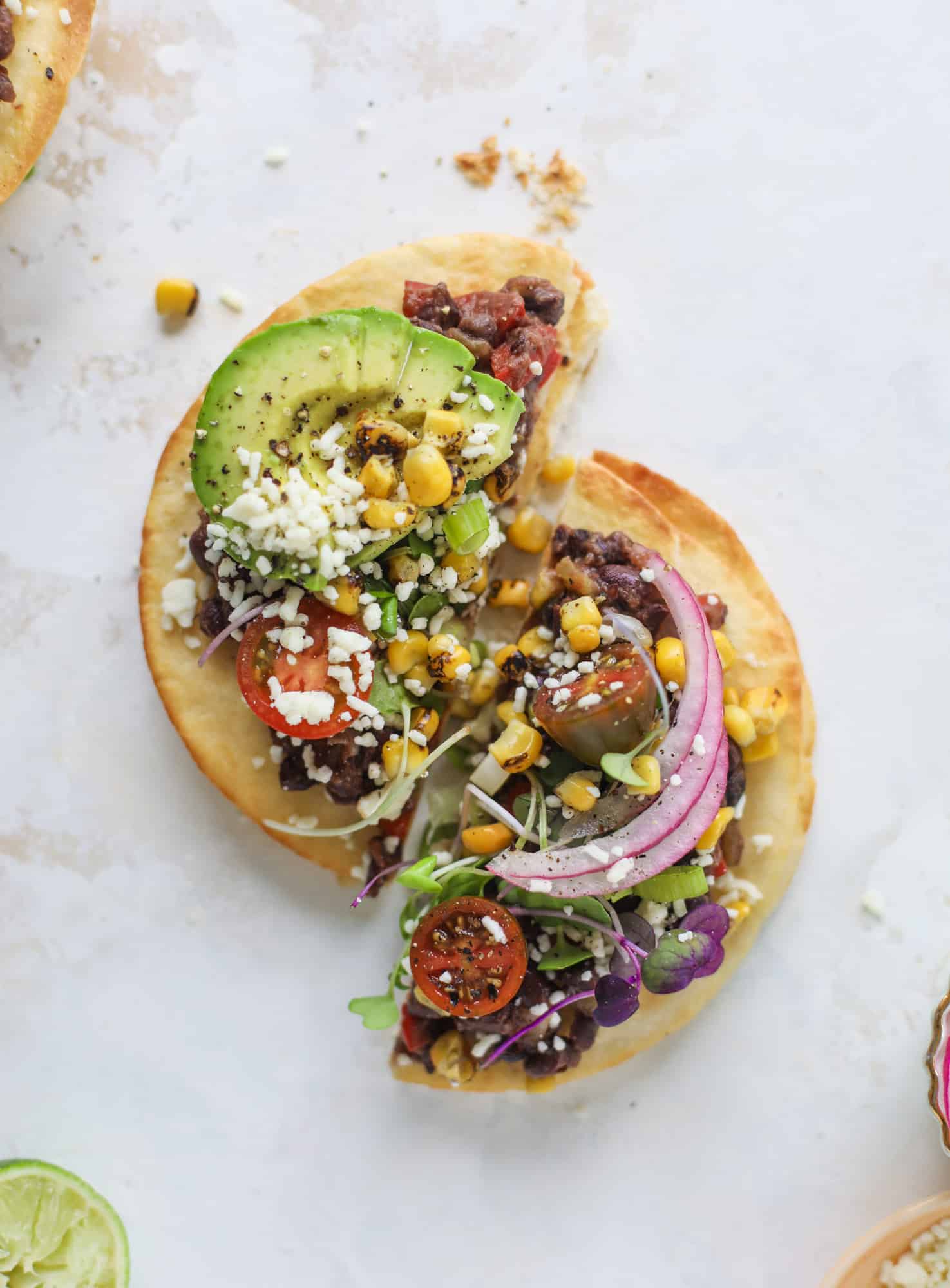 These saucy black bean tostadas are super flavorful and easy for a weeknight meal. Crunchy tortillas topped with beans and tons of veggies. Delish!