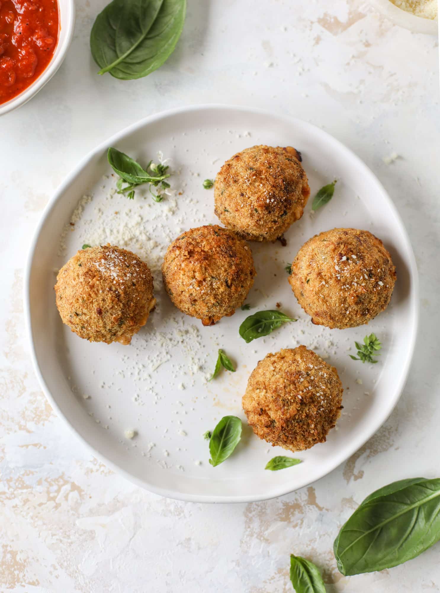 This cheesy cauliflower rice arancini is every bit as delicious as traditional arancini, and so much lighter! Cheesy on the side, crunchy on the outside.