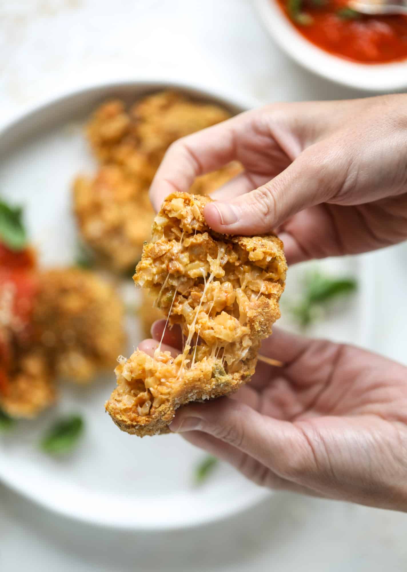 This cheesy cauliflower rice arancini is every bit as delicious as traditional arancini, and so much lighter! Cheesy on the side, crunchy on the outside.