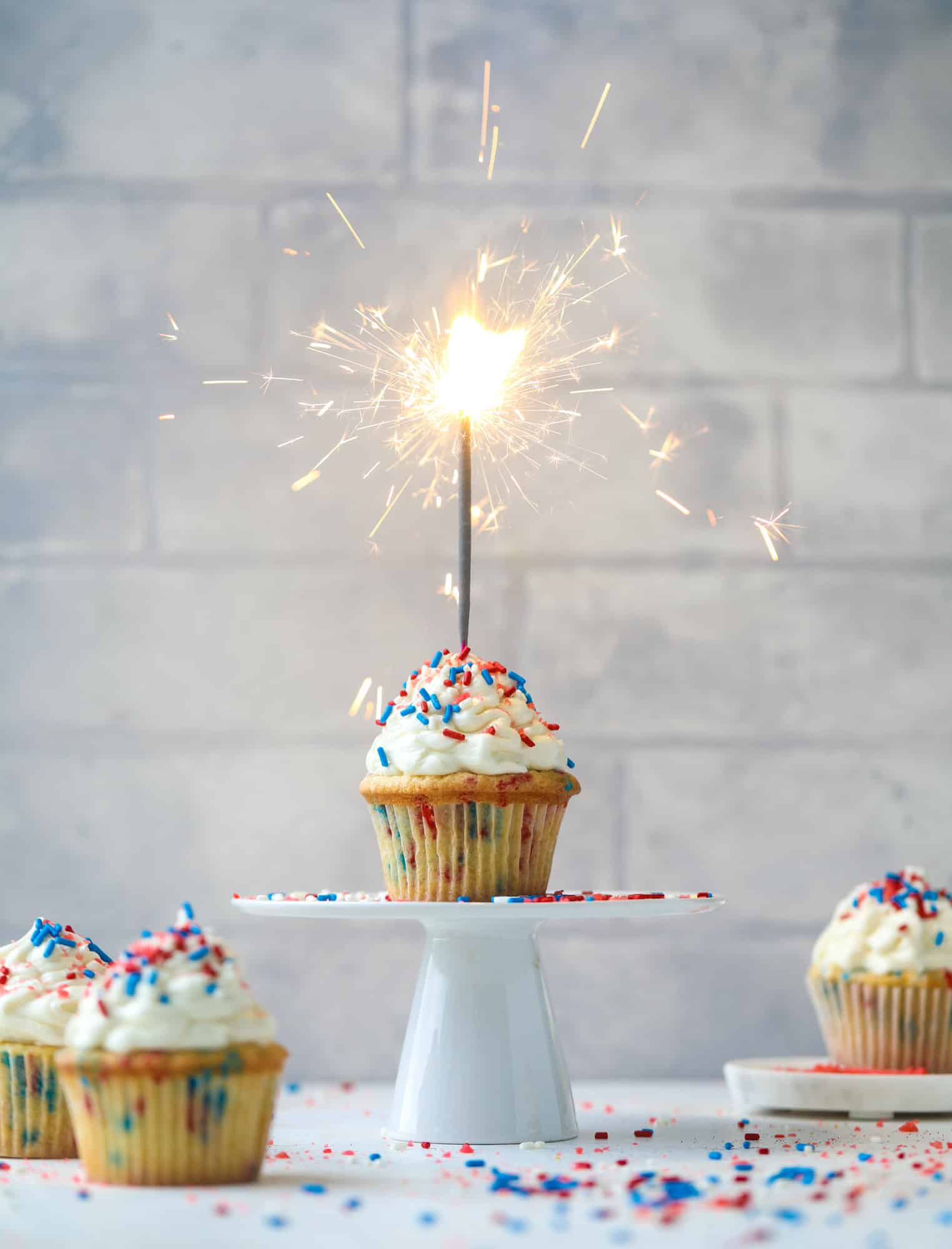 These 4th of July confetti cupcakes are super fun! Firecracker cupcakes with red, white and blue sprinkles and pop rocks candy on top for crackle!
