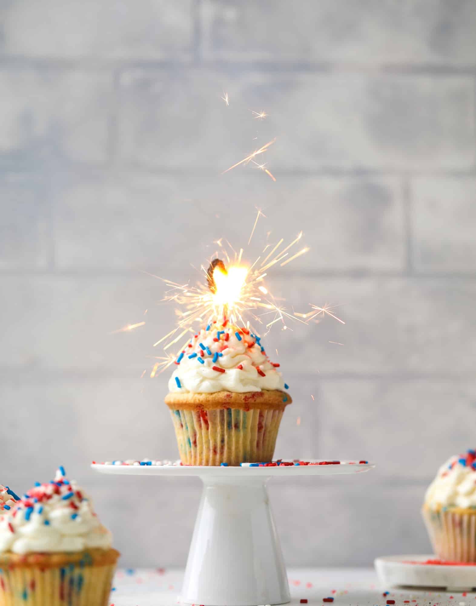 These 4th of July confetti cupcakes are super fun! Firecracker cupcakes with red, white and blue sprinkles and pop rocks candy on top for crackle!