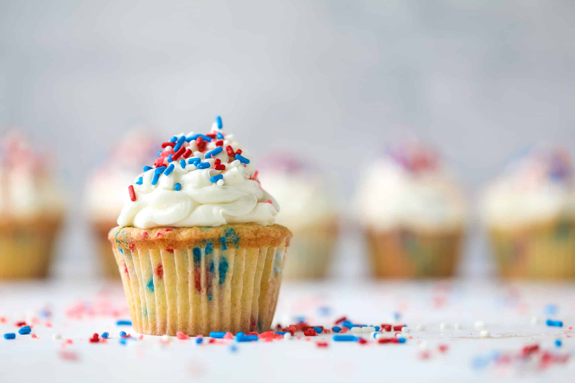 These 4th of July confetti cupcakes are super fun! Firecracker cupcakes with red, white and blue sprinkles and pop rocks candy on top for crackle!