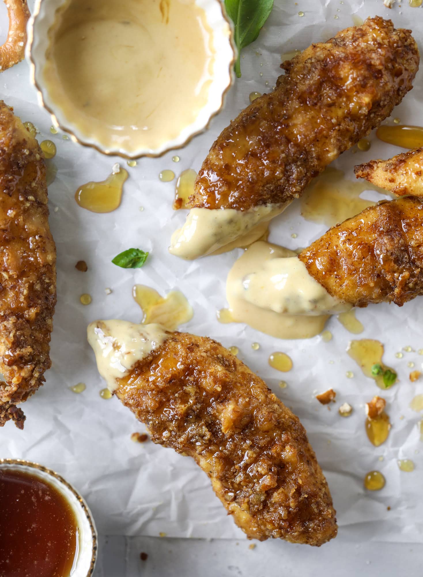 These pretzel crusted chicken fingers are baked, crunchy and ridiculously flavorful. Drizzle with hot honey and dip in house sauce. Yum!