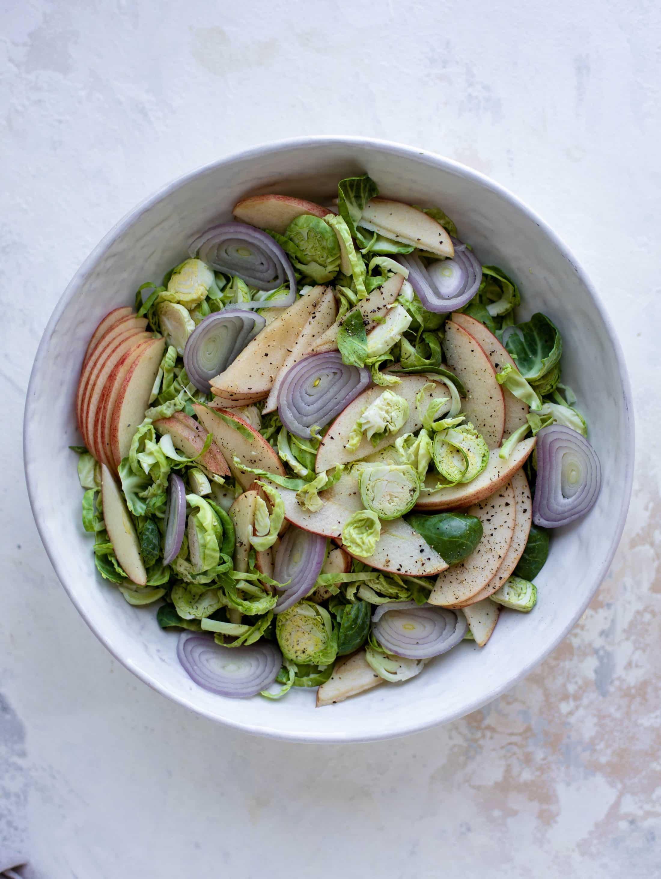 This crunchy brussels sprouts apple salad is filled with sprouts, apples, shallots, cinnamon toasted walnuts and drizzled with a brown butter dressing.