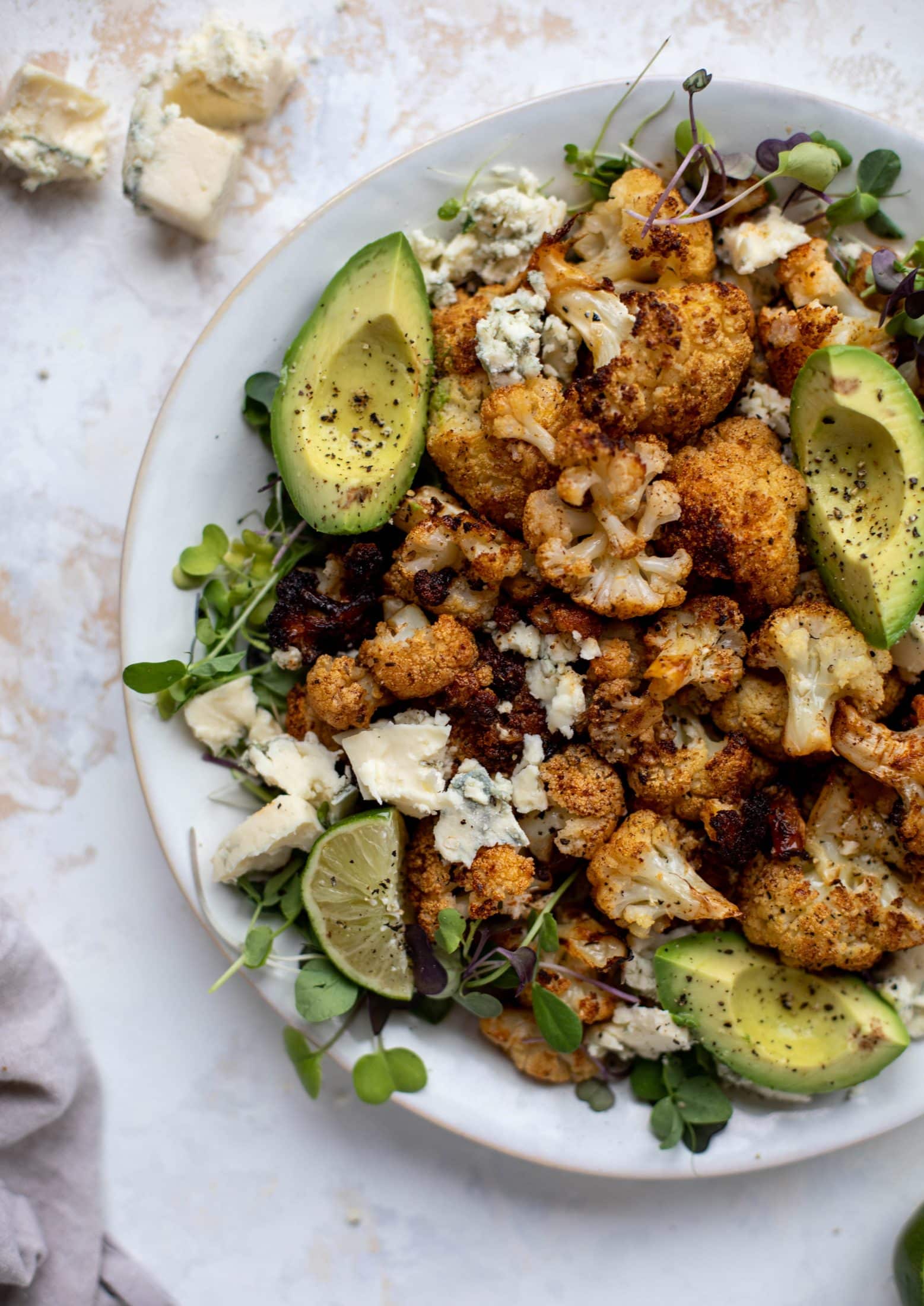 This crispy buffalo cauliflower is loaded with flavor! Serve with avocado and smoked blue cheese - you will want to eat this everyday!