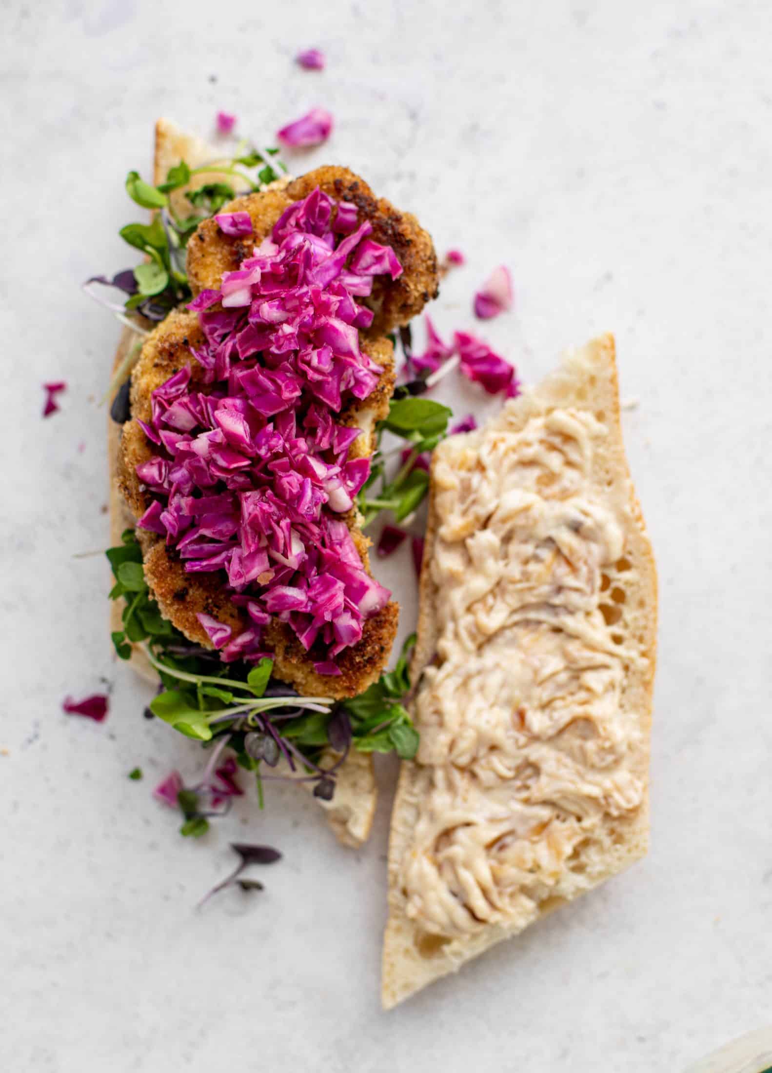 These cauliflower schnitzel sandwiches are full of flavor! Crispy cauliflower, caramelized onion mayo, pickled cabbage and microgreens. Delish!