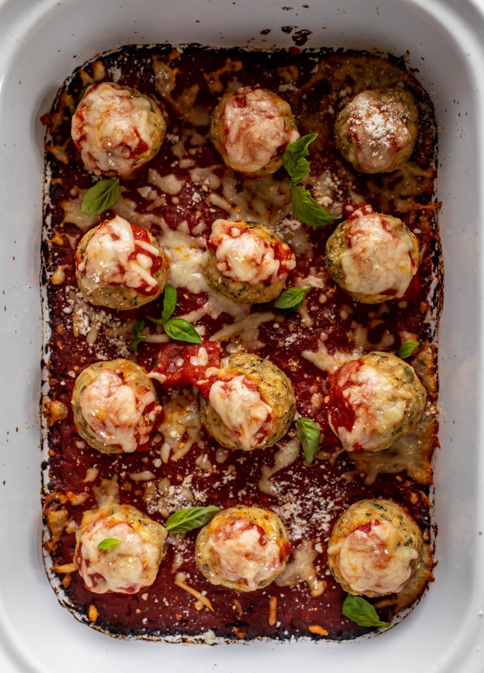 Chicken parmesan meatballs are baked and super flavorful! Serve with roasted garlic spaghetti for the best dinner ever! You can make them ahead of time too!