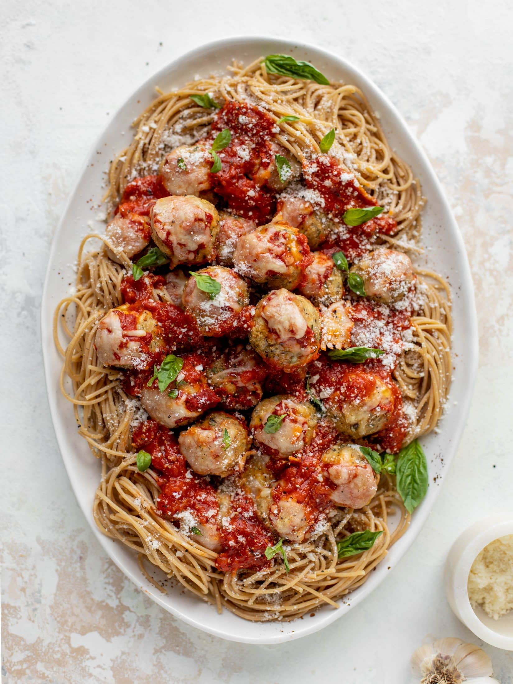 Chicken parmesan meatballs are baked and super flavorful! Serve with roasted garlic spaghetti for the best dinner ever! You can make them ahead of time too!