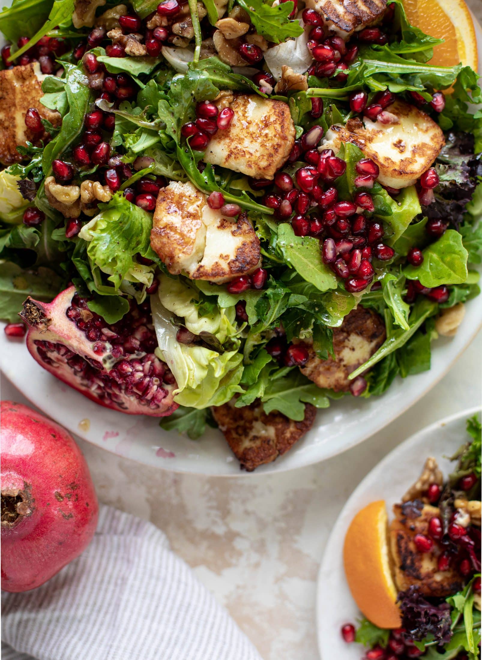 A pomegranate halloumi salad that's the perfect starter to your holiday meal! Drizzle with a spiced orange vinaigrette for the most festive flavor ever.
