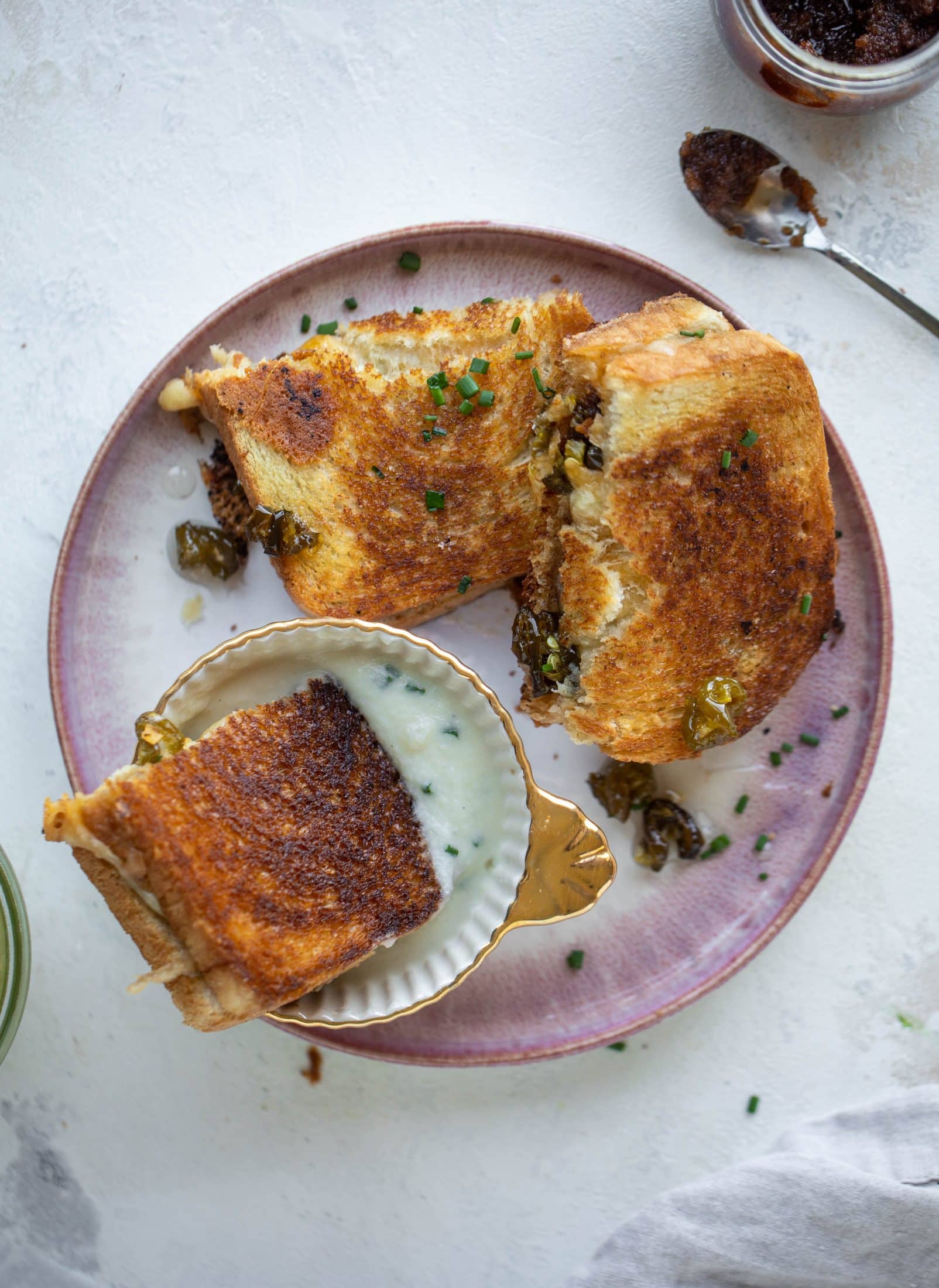 This bacon grilled cheese is filled with sharp cheddar and candied jalapeños! Served alongside a soup dipped for the ultimate comforting meal.