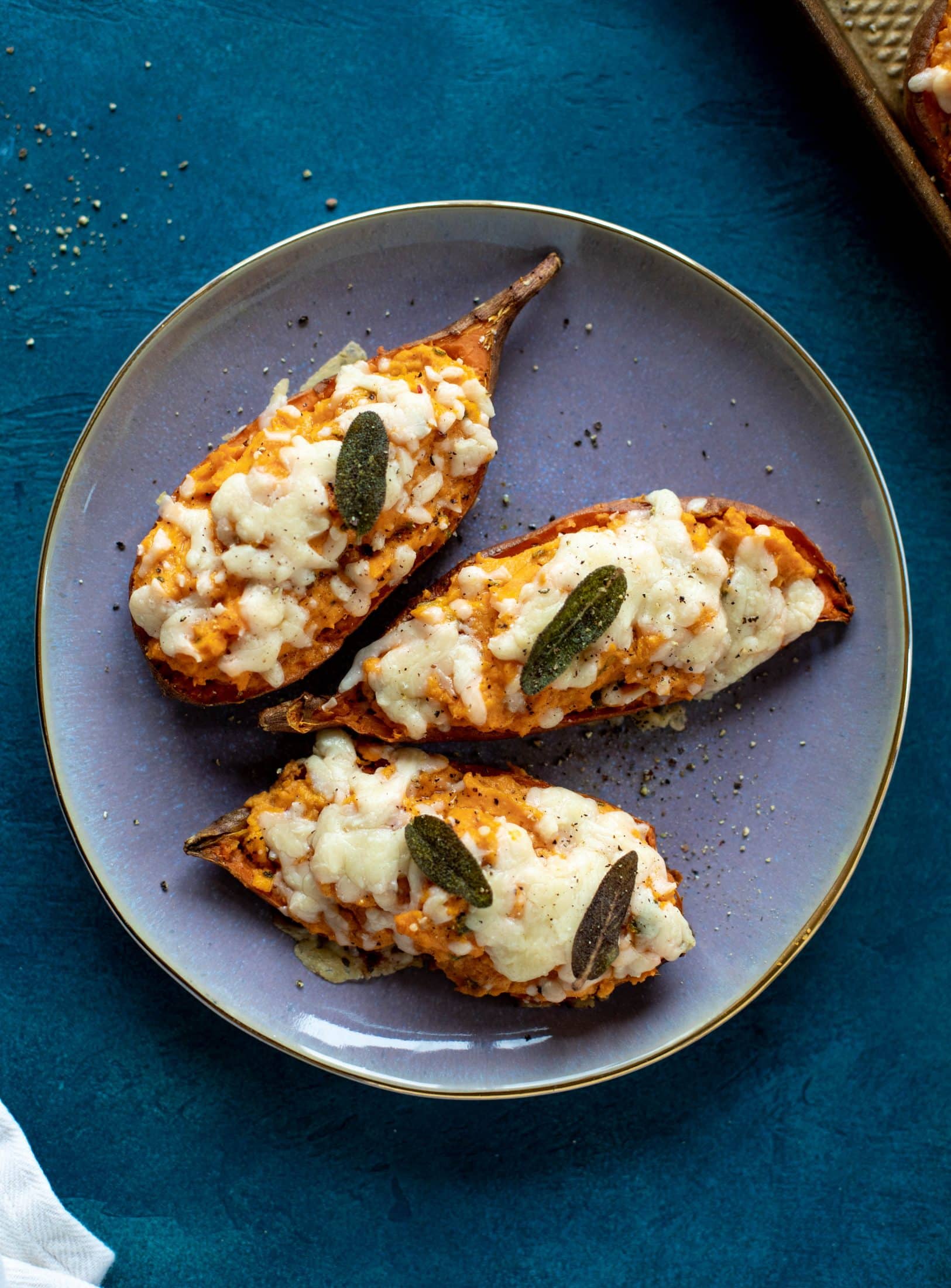 These twice baked sweet potatoes are whipped with crispy sage and pumpkin puree! Topped with cheese and baked until melty, they are super delish.