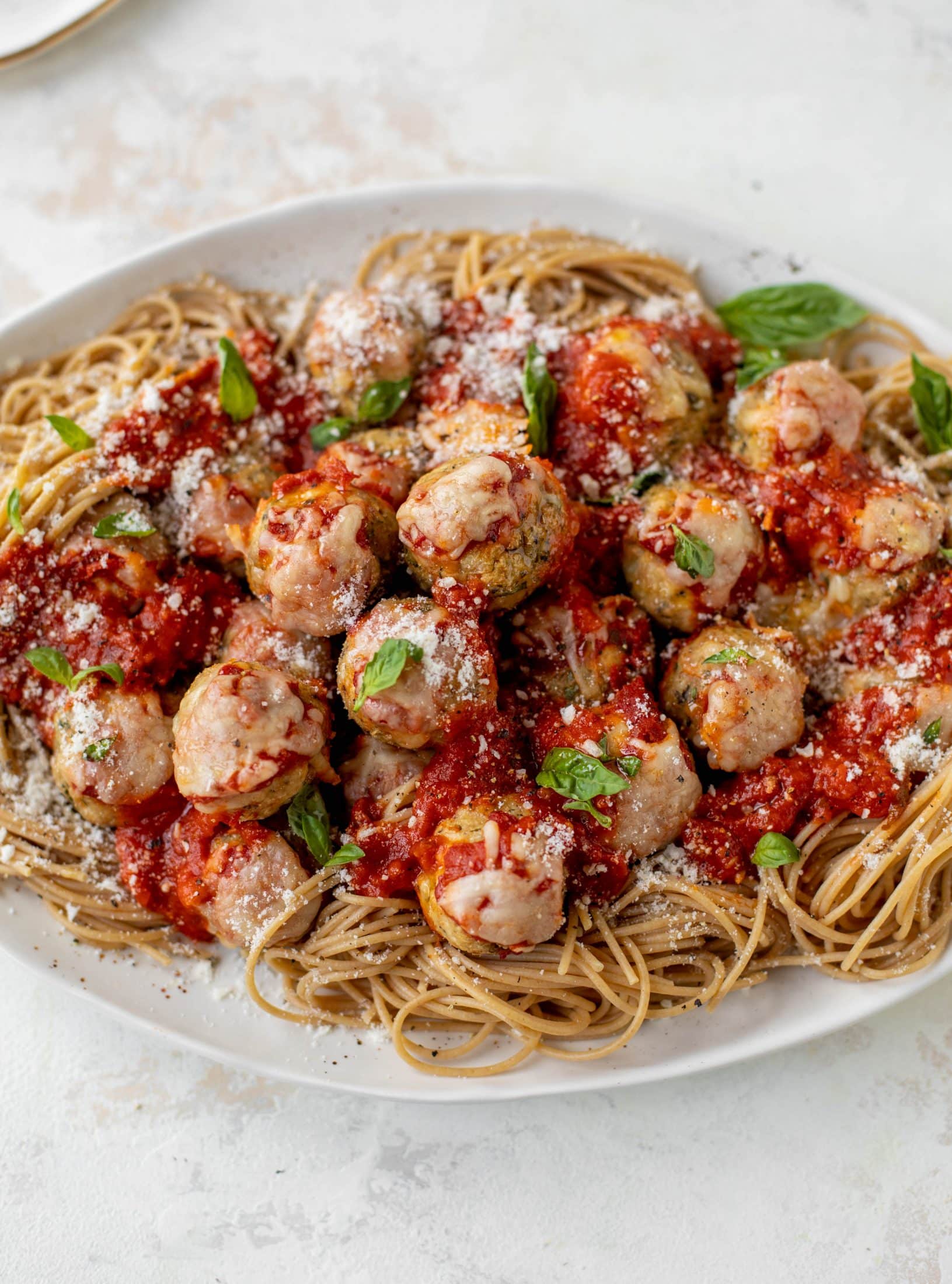 Chicken parmesan meatballs are baked and super flavorful! Serve with roasted garlic spaghetti for the best dinner ever! You can make them ahead of time too!