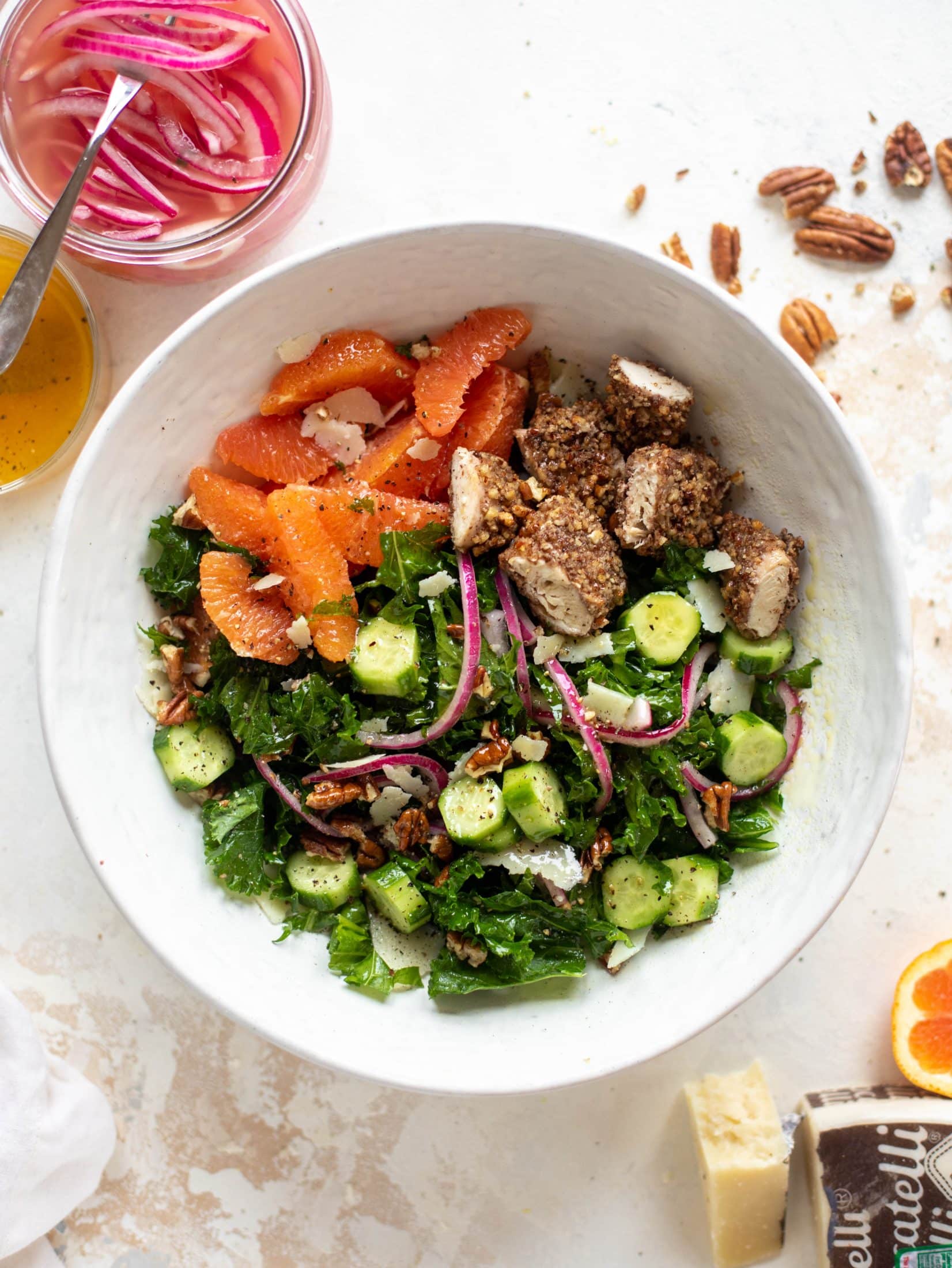 This pecan crusted chicken salad is so hearty! Kale, cara cara oranges, pickled onions, cucumbers and pecorino make this a bowl of flavor.