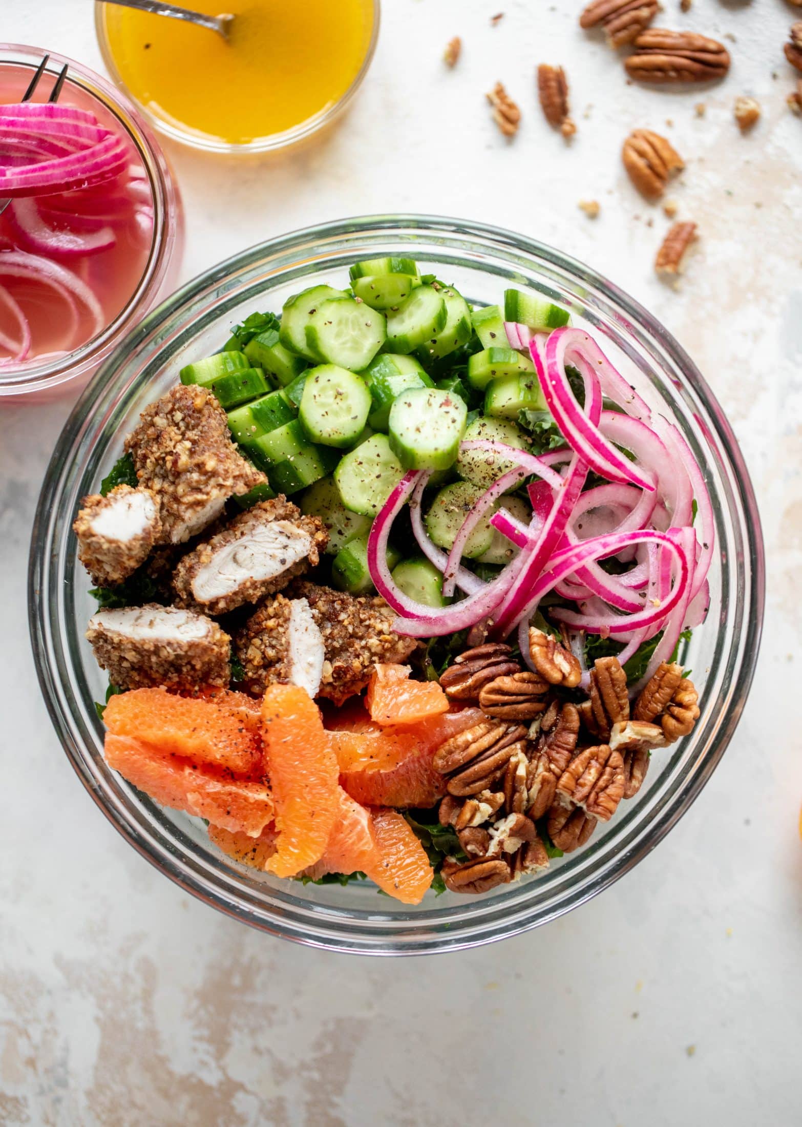 This pecan crusted chicken salad is so hearty! Kale, cara cara oranges, pickled onions, cucumbers and pecorino make this a bowl of flavor.