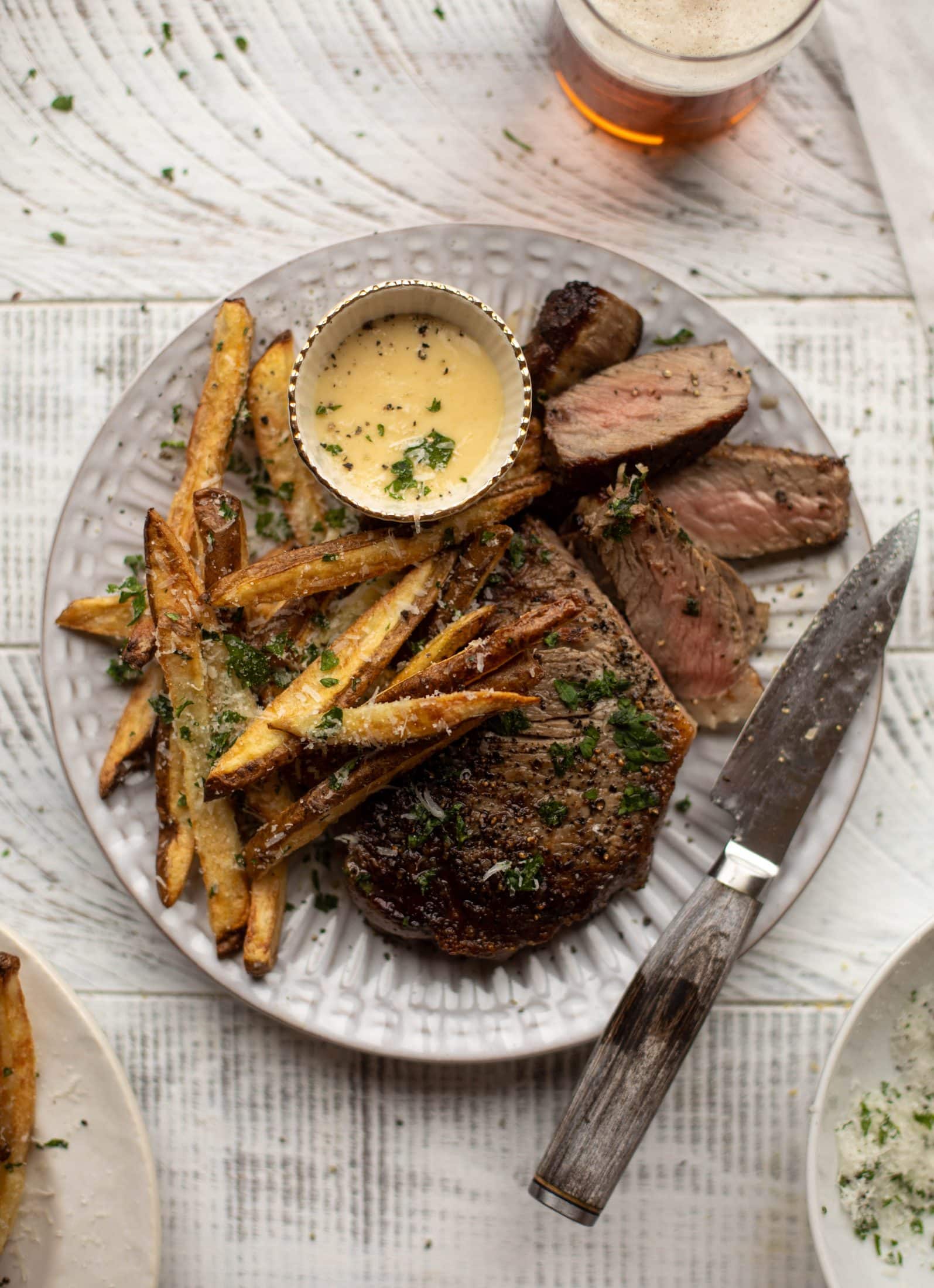 This is our favorite steak frites! Seared skillet steak and crispy fries made in the air fryer, topped with truffle salt, parmesan and herbs!