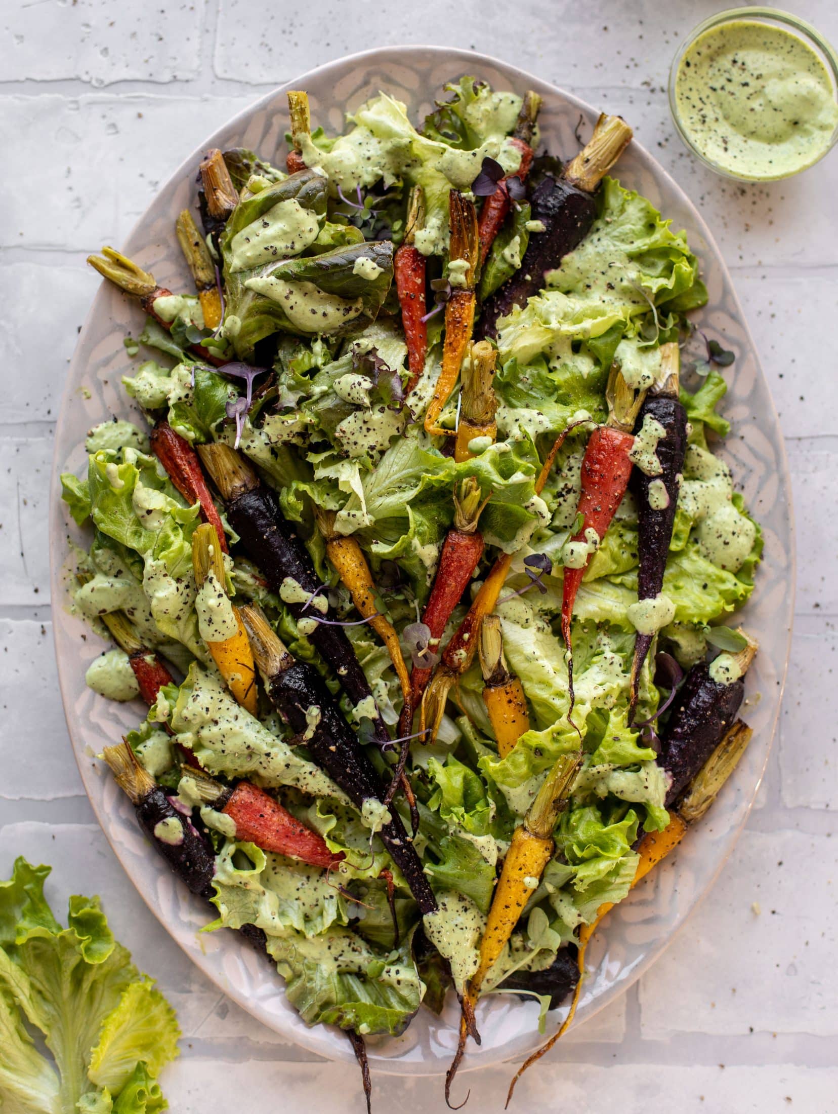 This roasted carrot salad is perfect for spring! Caramely, roasted carrots served over butter greens dressing with green goddess. Simple but delish.