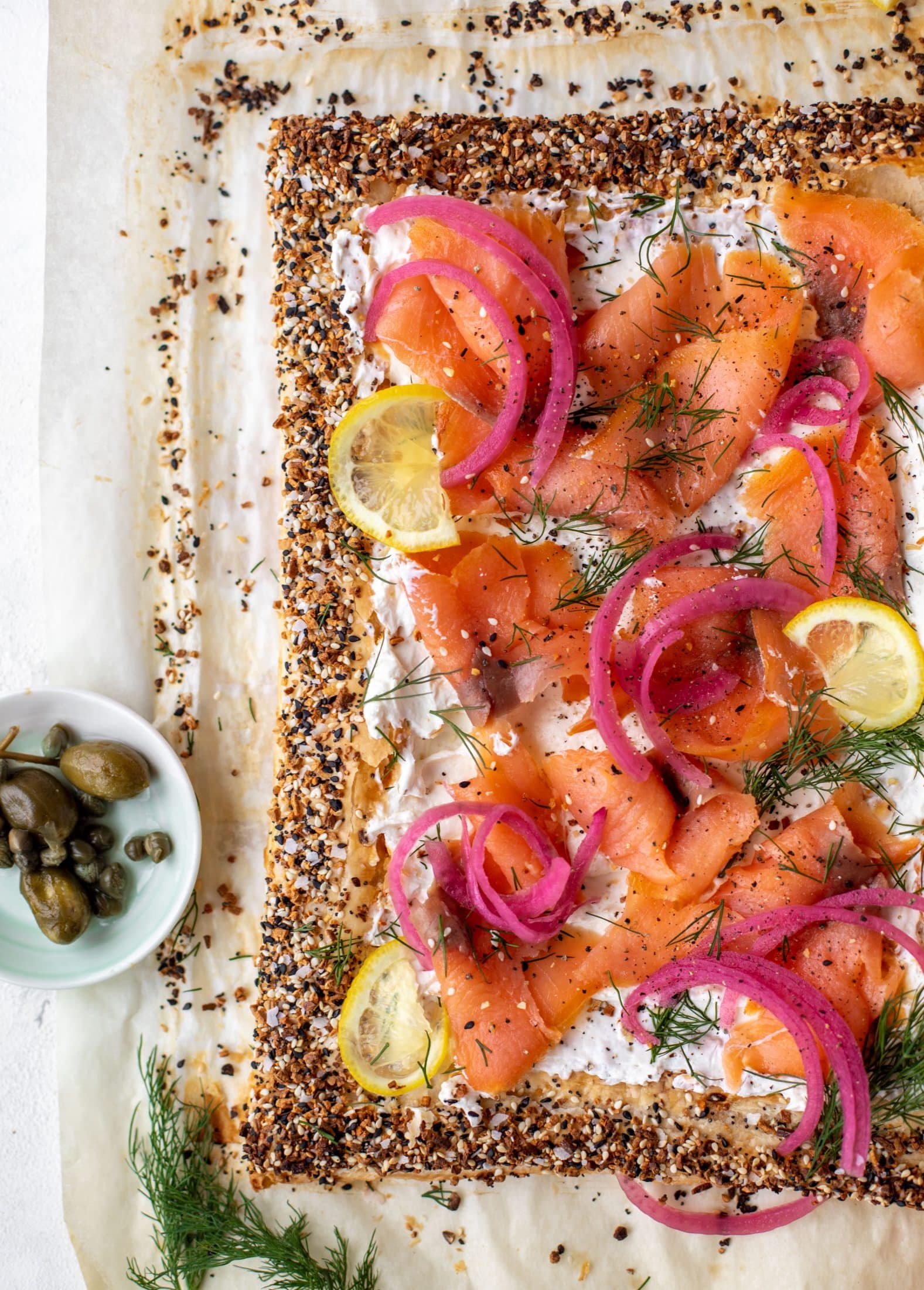This everything smoked salmon tart is perfect for brunch! Puff pastry sprinkled with everything seasoning, slathered in cream cheese and topped with salmon.