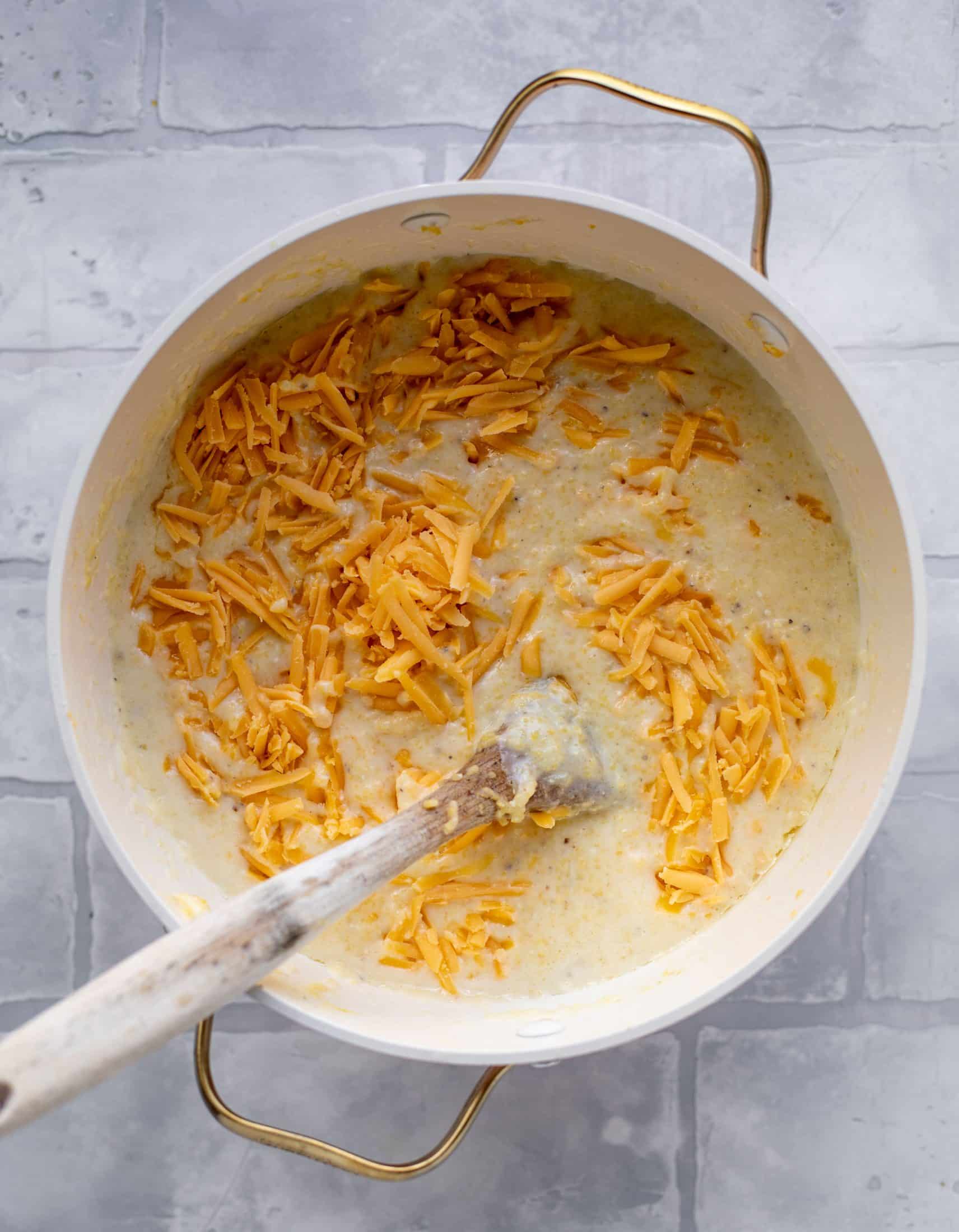 stirring cheddar into grits