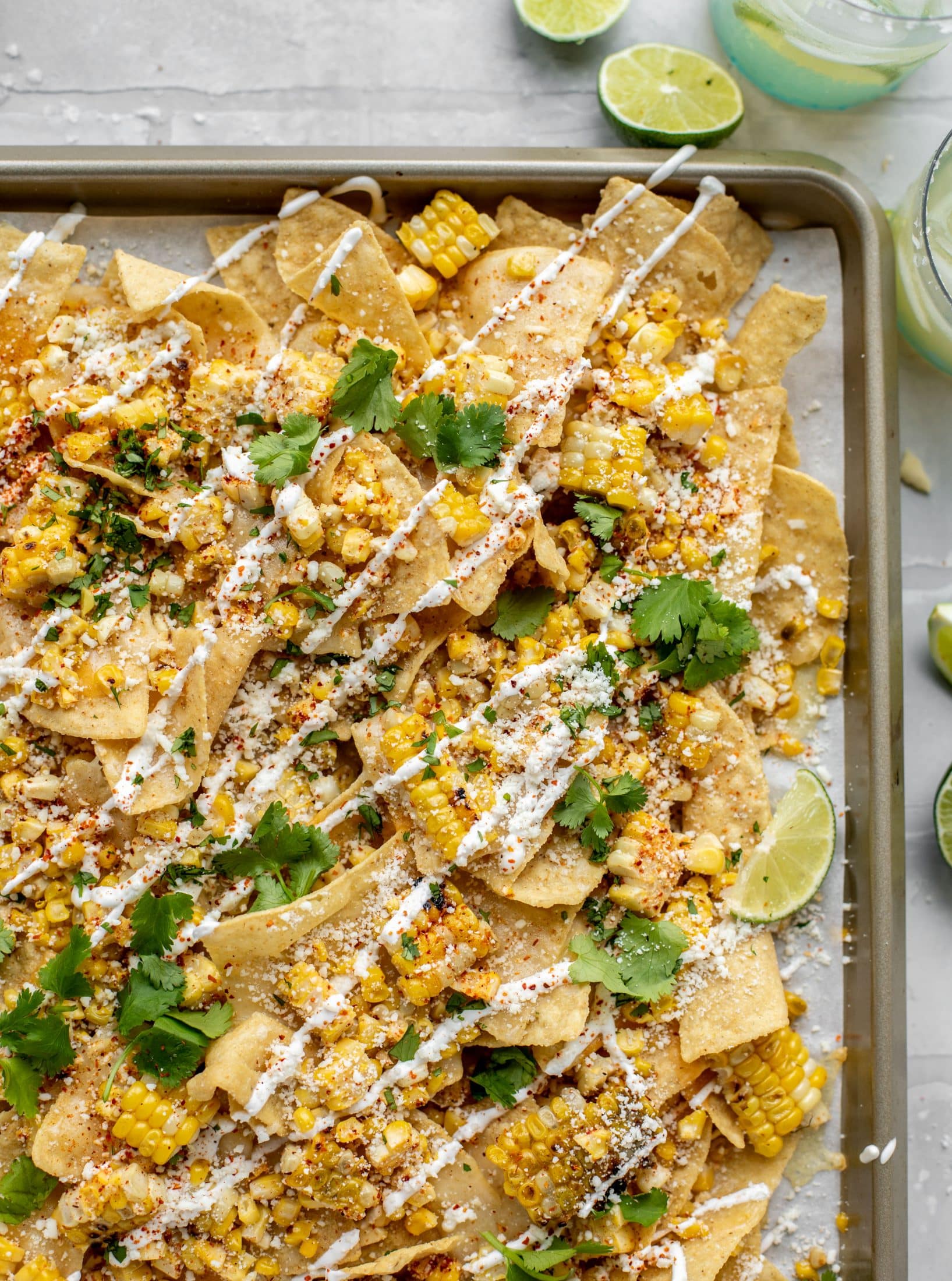 These sheet pan street corn nachos are ridiculously easy and delicious! Grilled corn, chili, lime, tons of cheese and all the flavor you could dream of!