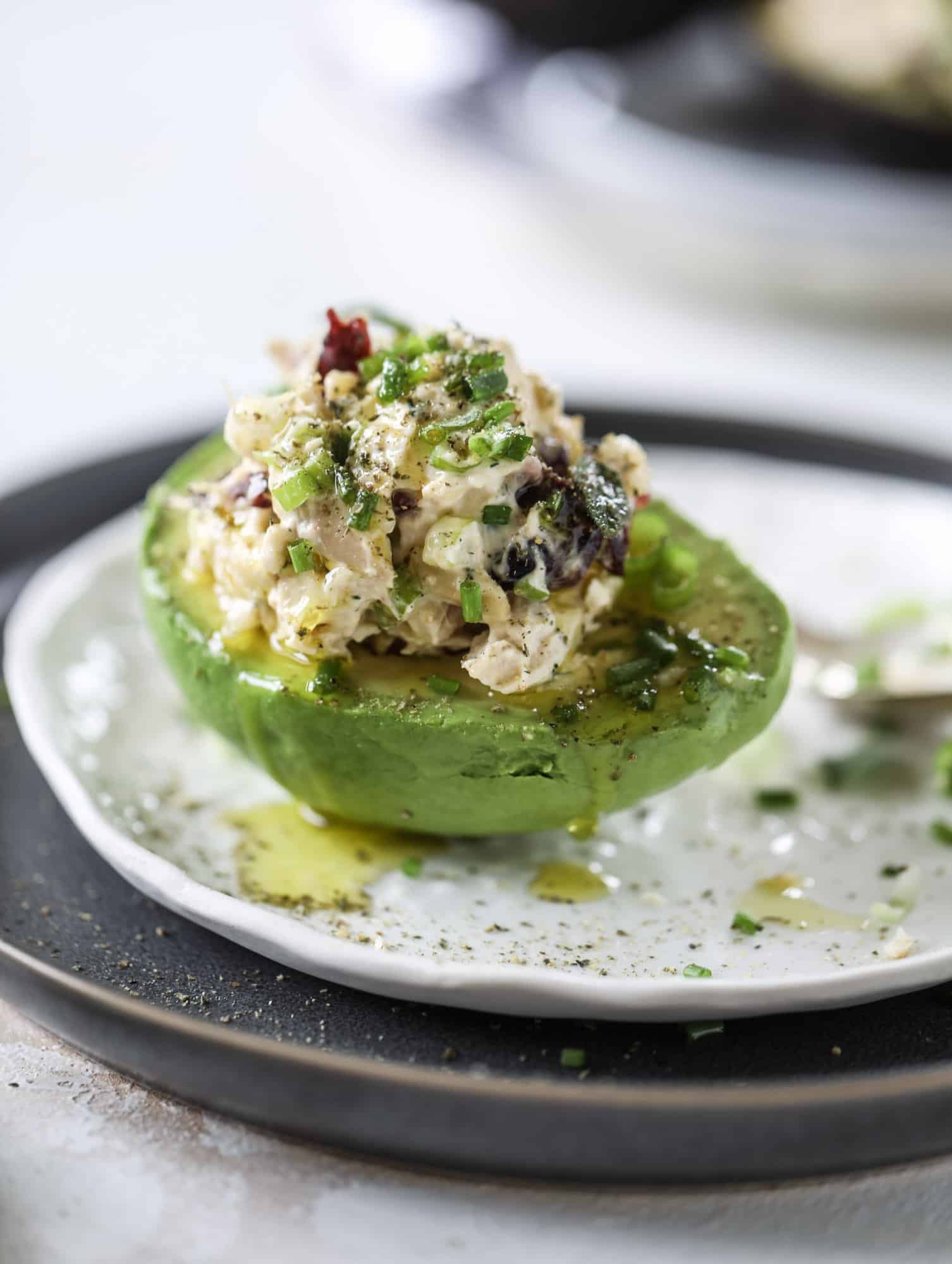 These smoky chicken salad stuffed avocados are lunchtime gold! They are super easy to throw together, satisfying and pretty darn great for you. Made with greek yogurt, some tangy mustard and dried cherries for sweetness, they are delish! I howsweeteats.com #chicken #salad #stuffed #avocados #greekyogurt