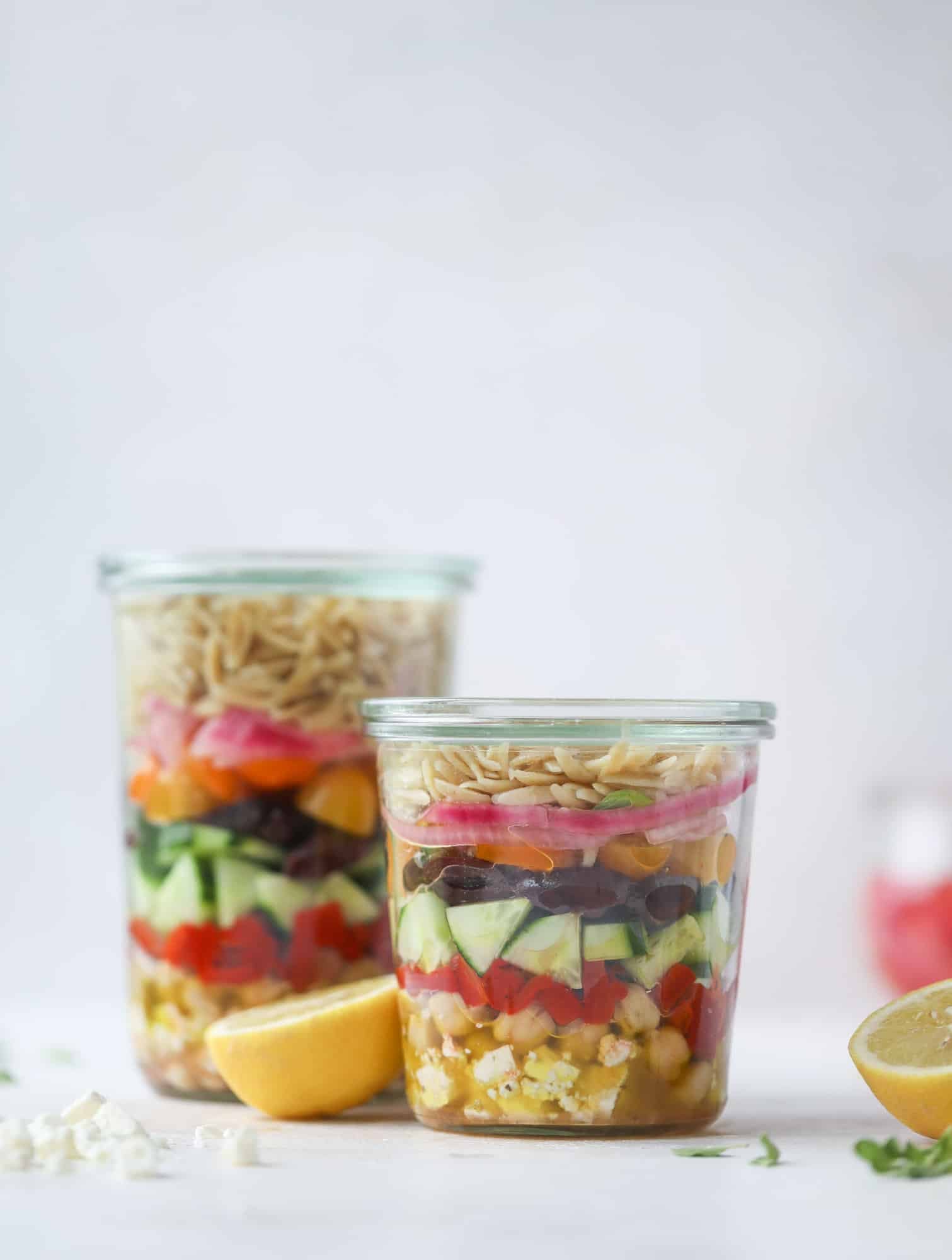 This incredible greek orzo salad in a jar is to die for! The recipe is so easy and flavorful, super satisfying and perfect for meal prep. This salad in a jar is a delicious lunch idea for the weekdays and keeps you feeling full and happy! I howsweeteats.com #salad #jar #greek #orzo #recipes #healthy #lunch #mealprep