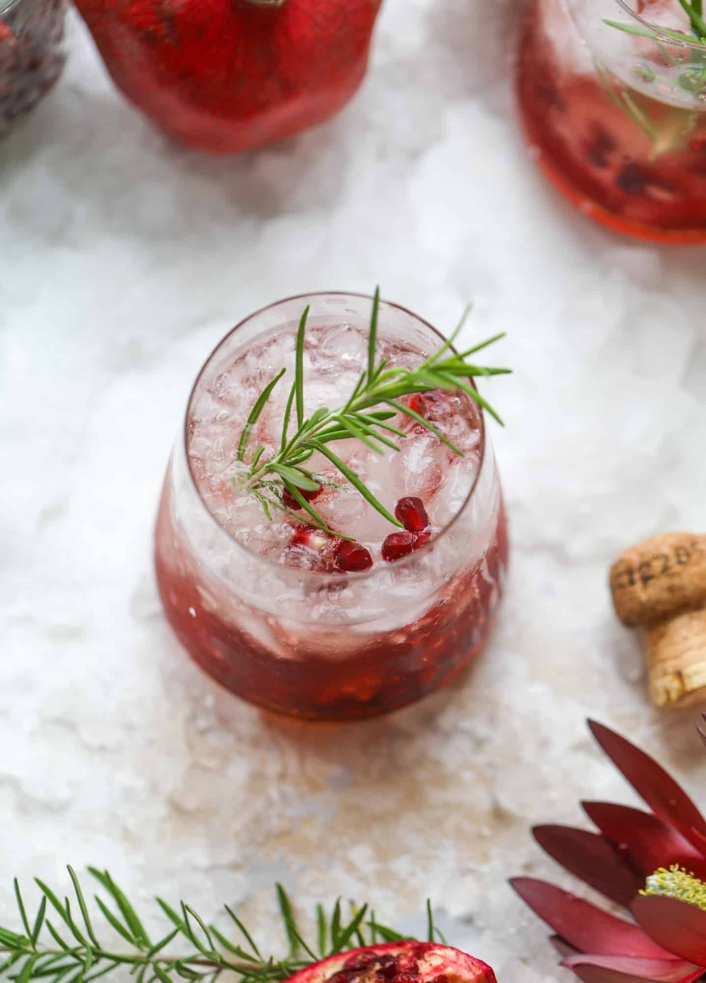 The pomegranate smash cocktail is a great drink for fall, Thanksgiving and the holiday season. Pomegranate juice, vodka and prosecco create a bubbly delicious drink that is garnished with pomegranate arils and rosemary. So festive! I howsweeteats.com #pomegranate #smash