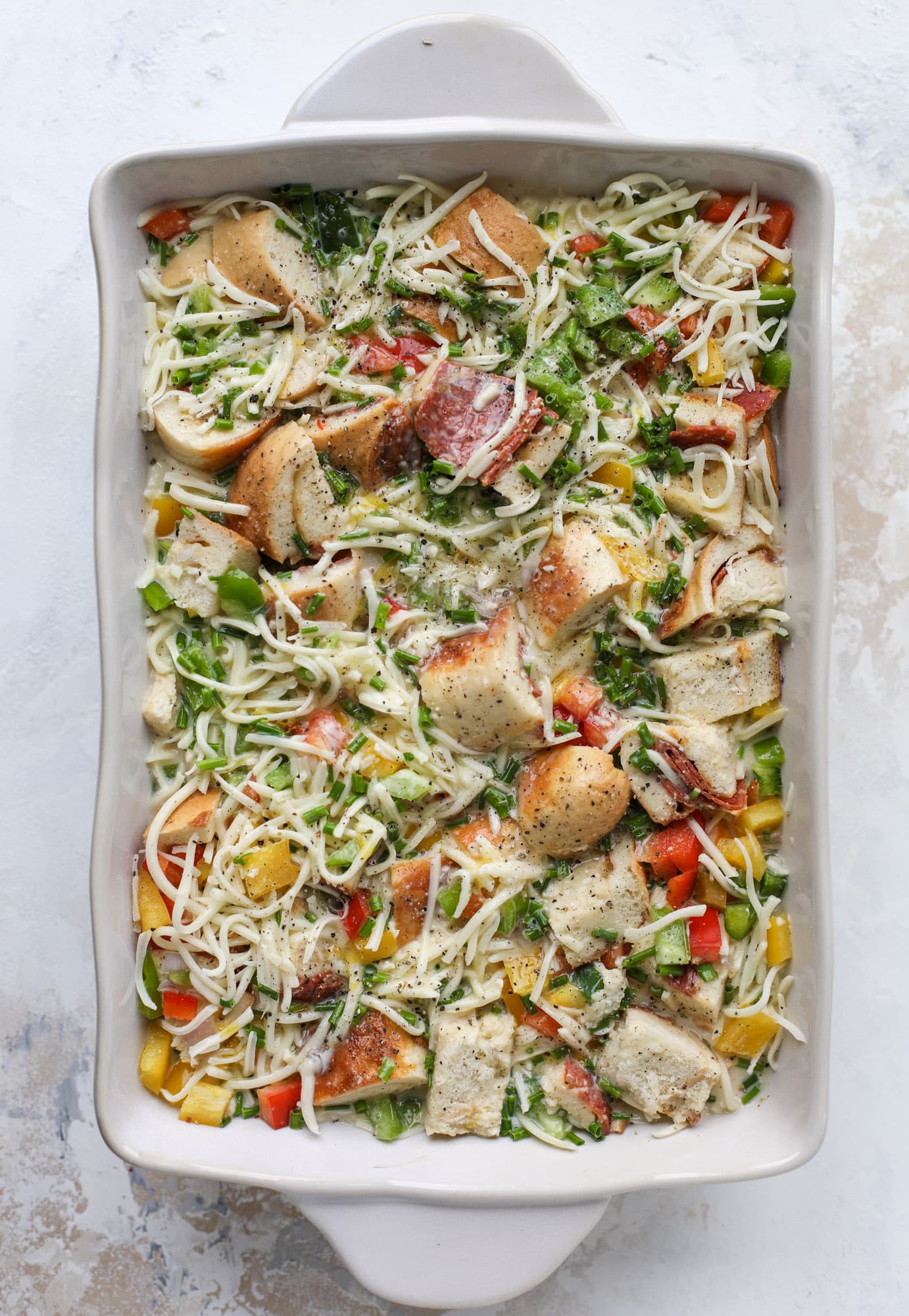 This breakfast strata is super special because the base is built on pepperoni rolls! This make ahead casserole is perfect for holiday brunches or parties and tastes like a supreme pizza. It's so easy to throw together too! I howsweeteats.com #breakfast #strata