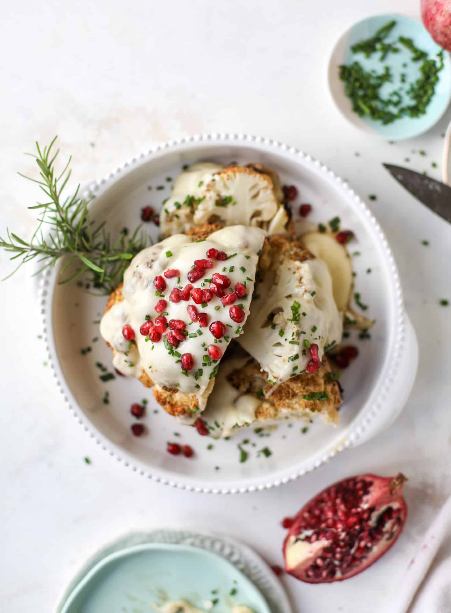 This whole roasted cauliflower fondue is roasted to toasty perfection and then covered in a fondue cheese sauce! Sprinkled with a festive garnish, it's the perfect appetizer or side dish for your dinner party, weeknight meal or movie night! I howsweeteats.com #wholeroasted #cauliflower